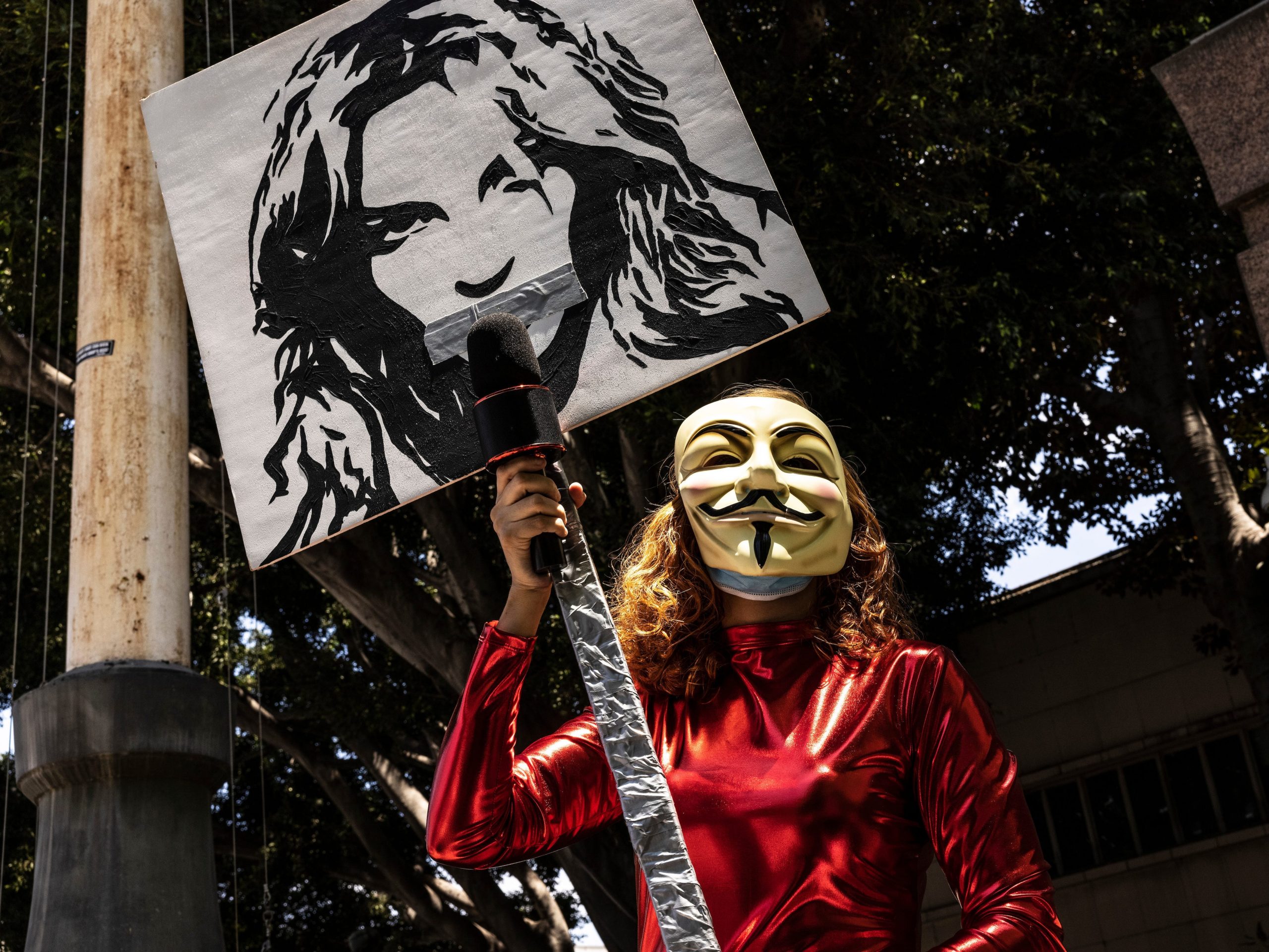 A mask-wearing #FreeBritney supporter holds a poster of Britney Spears outside the Stanley Mosk Courthouse building in downtown Los Angeles