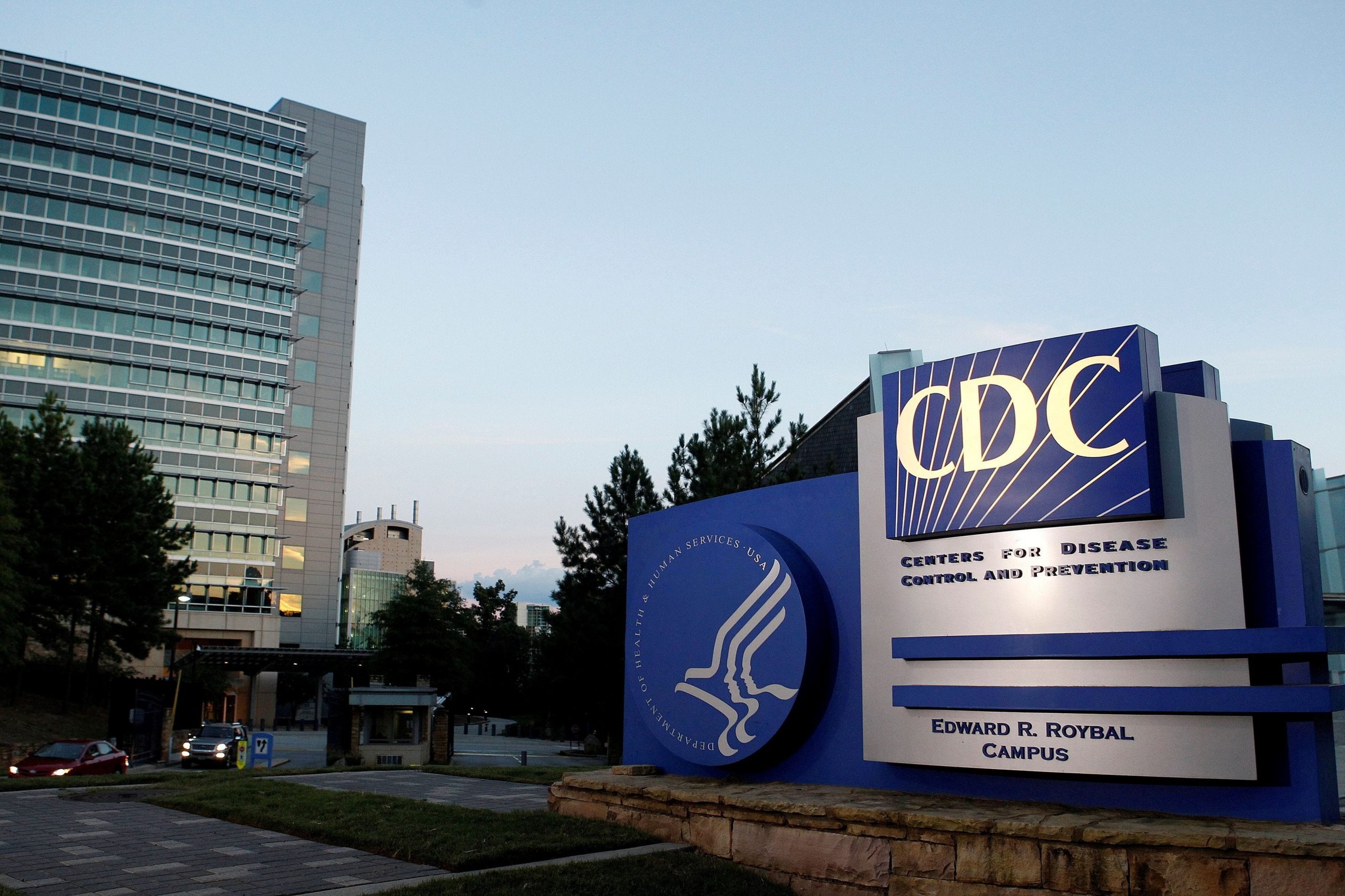 The blue-and-white CDC sign in front of the agency's Atlanta headquarters at sunset