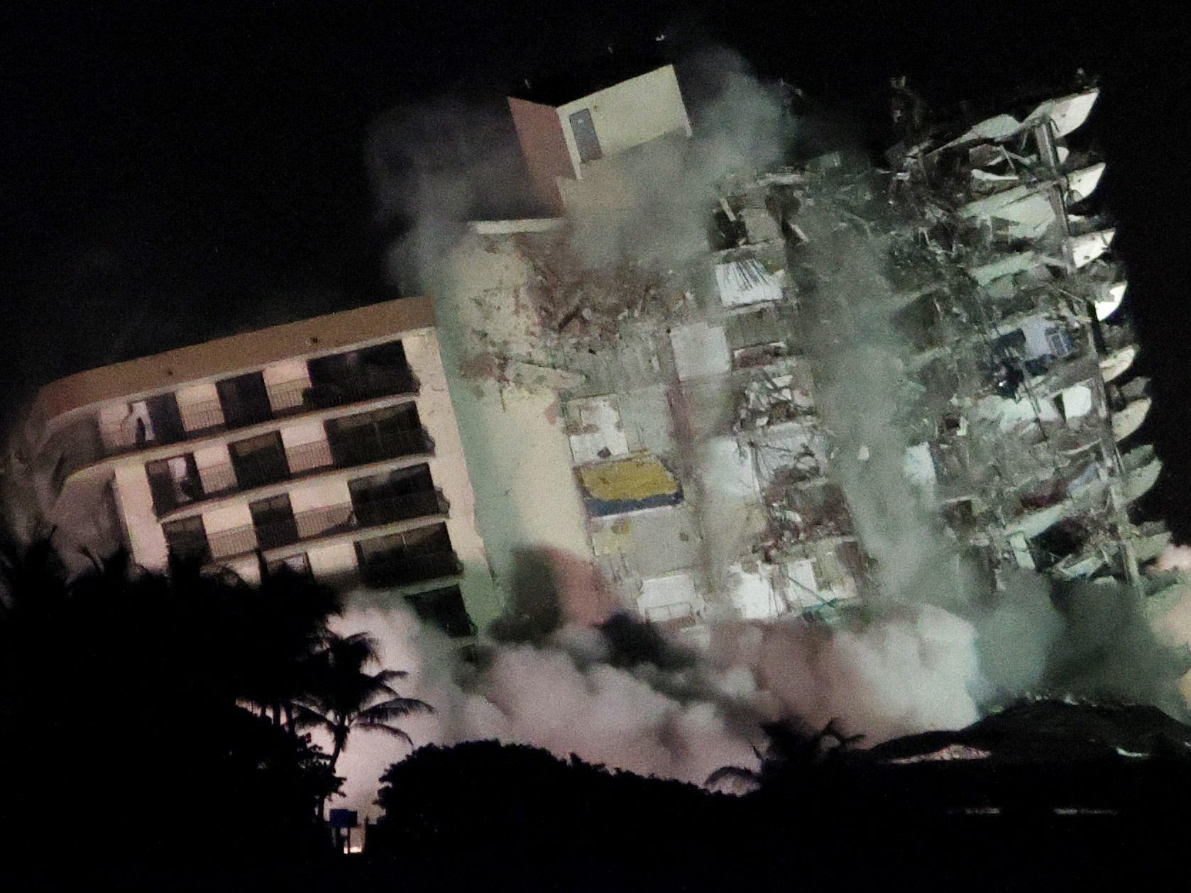 The remaining part of the partially collapsed 12-story Champlain Towers South condo building falls with a controlled demolition on July 4, 2021 in Surfside, Florida.