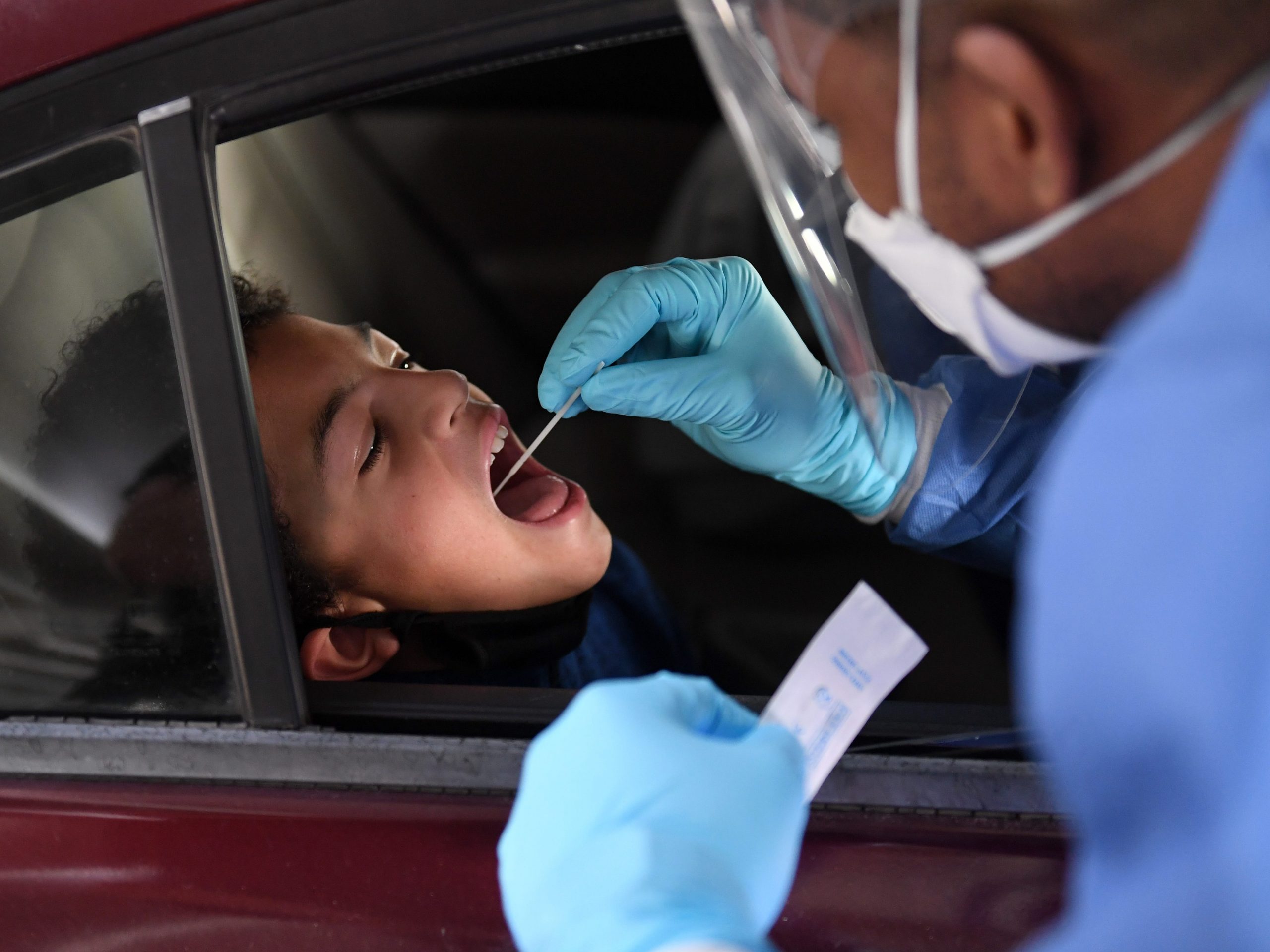 Spc. Demetrie Barnett of the Nevada National Guard administers a COVID-19 test to Josiah Smith, 12, of Nevada, during a preview of a free drive-thru COVID-19 testing site in the parking garage of the Texas Station Gambling Hall & Hotel on November 12, 2020 in North Las Vegas, Nevada.