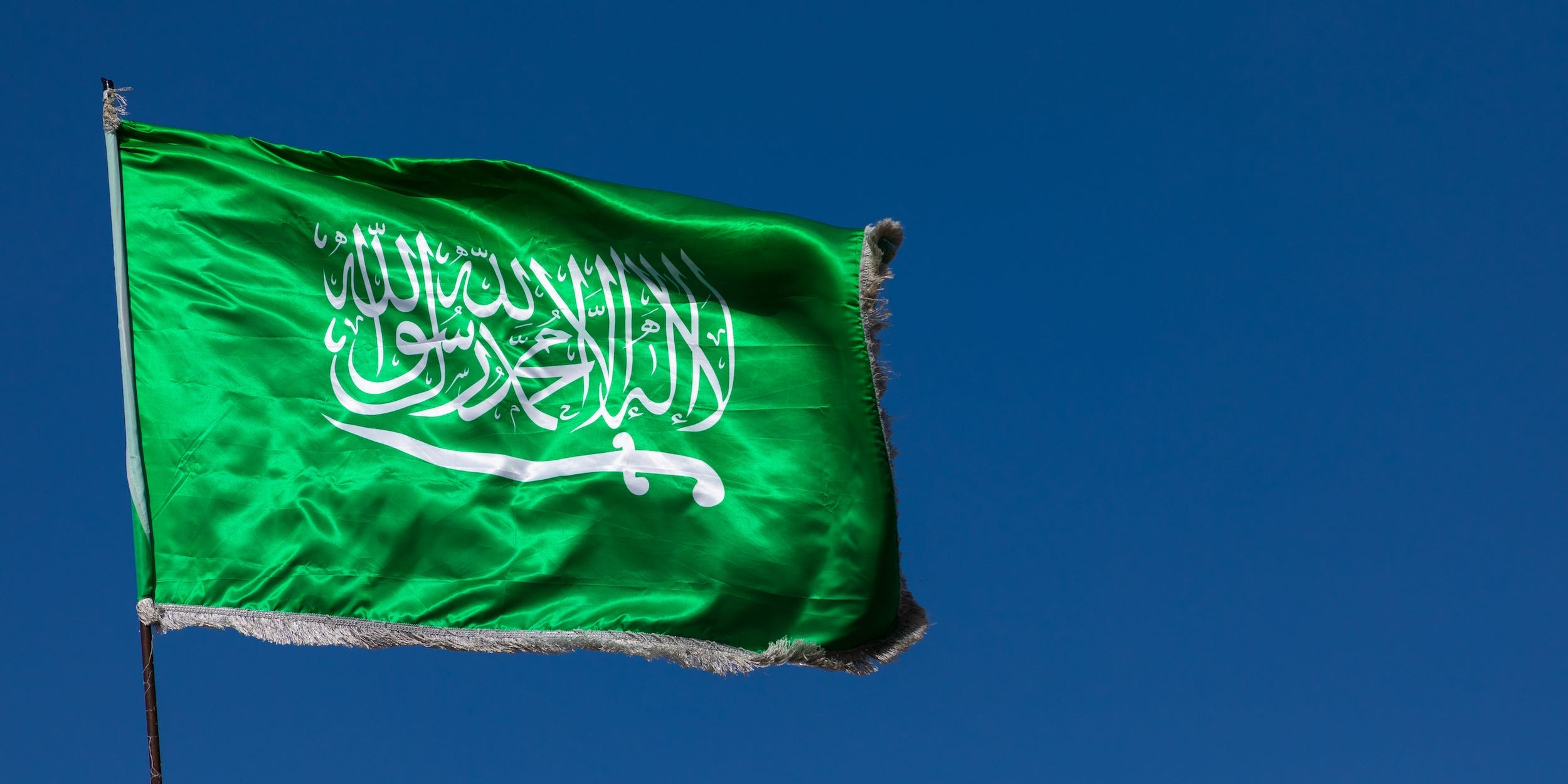 A Saudi Arabian flag in the wind against clear sky in the Al Madinah Province, Yanbu, Saudi Arabia on December 26, 2019.