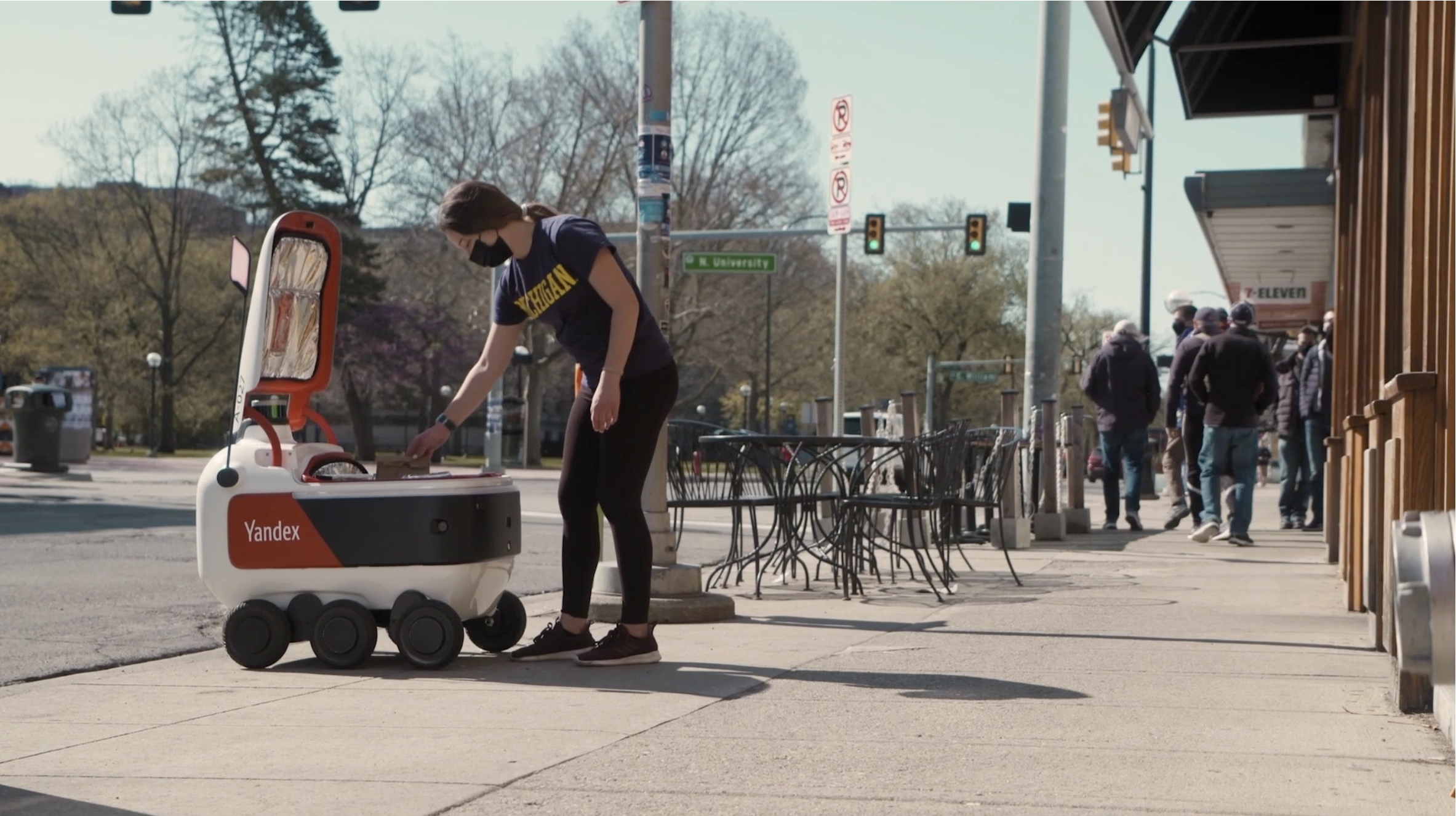 A women picking up her delivery from Grubhub's autonomous robot