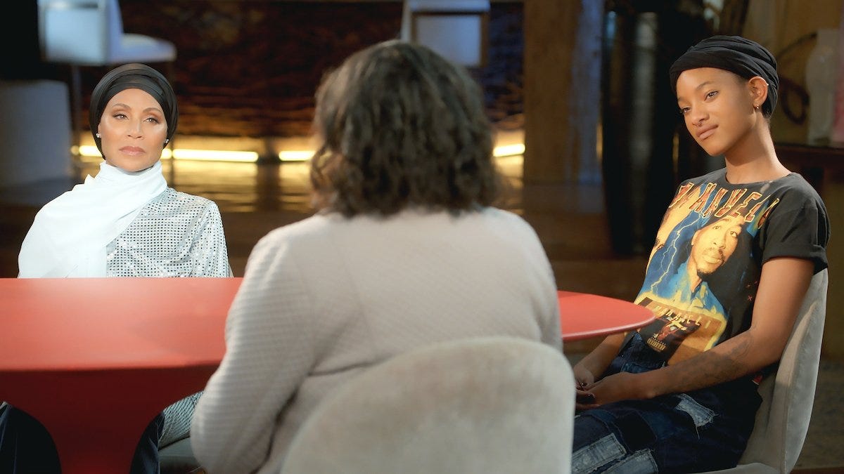 Jada Pinkett Smith and Willow Smith sitting at a red table