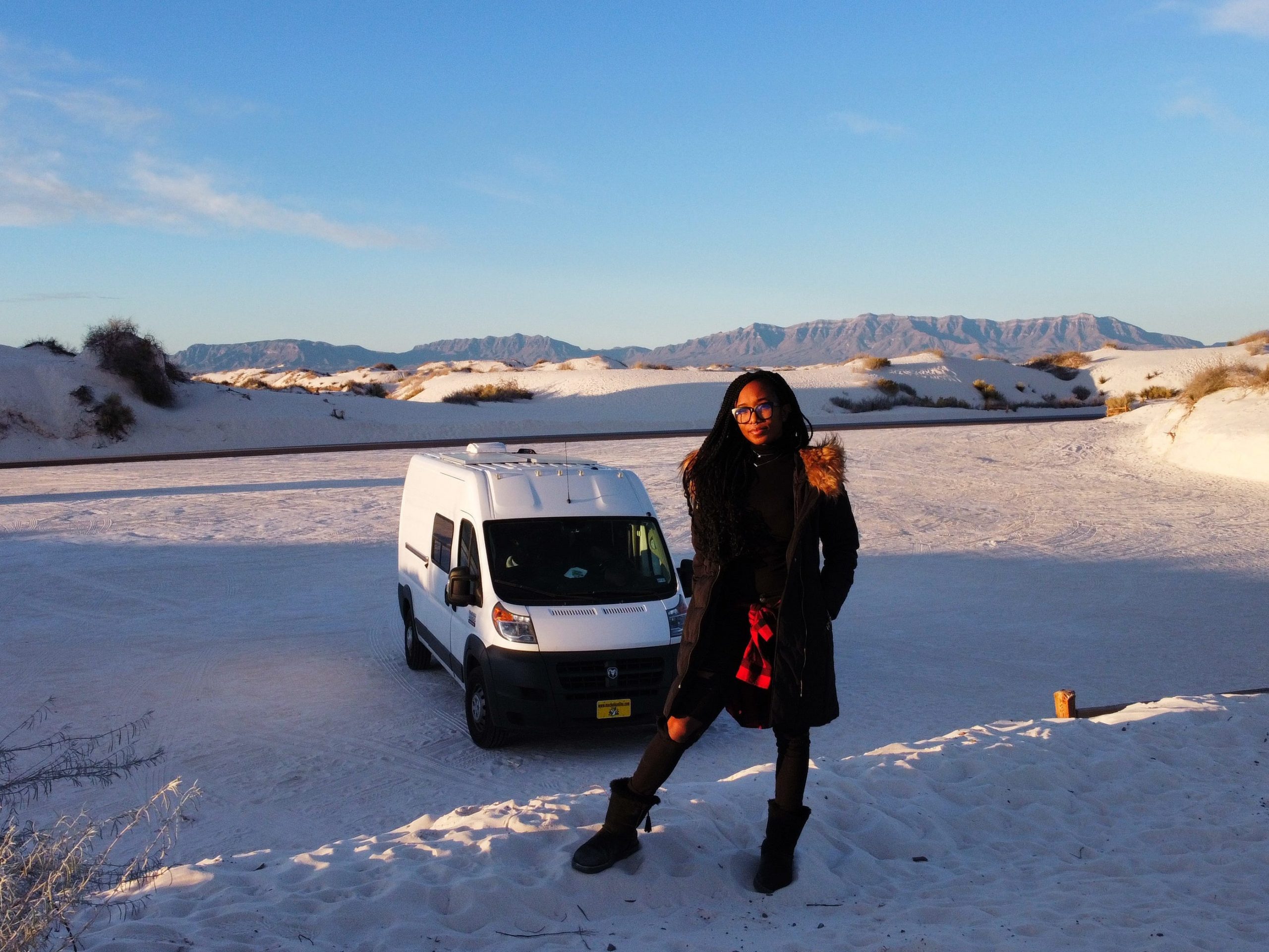 woman standing in front of white van on snow