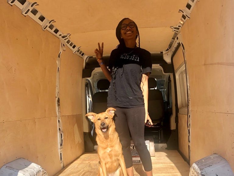 woman standing in an empty van with her dog