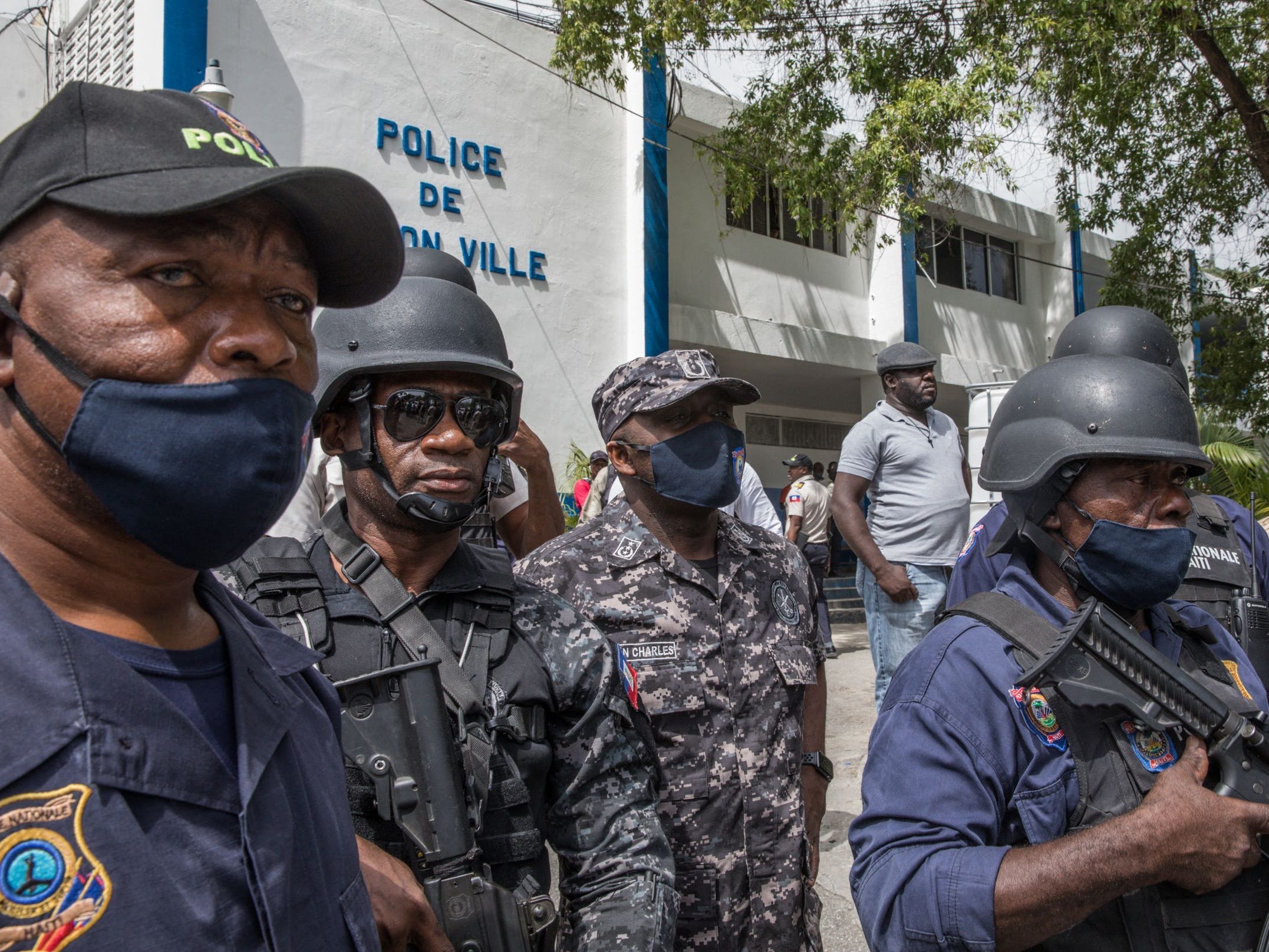 Leon Charles, head of the Police Ntionale of Haiti (C), looks on as the crowd surrounds the Petionville Police station.