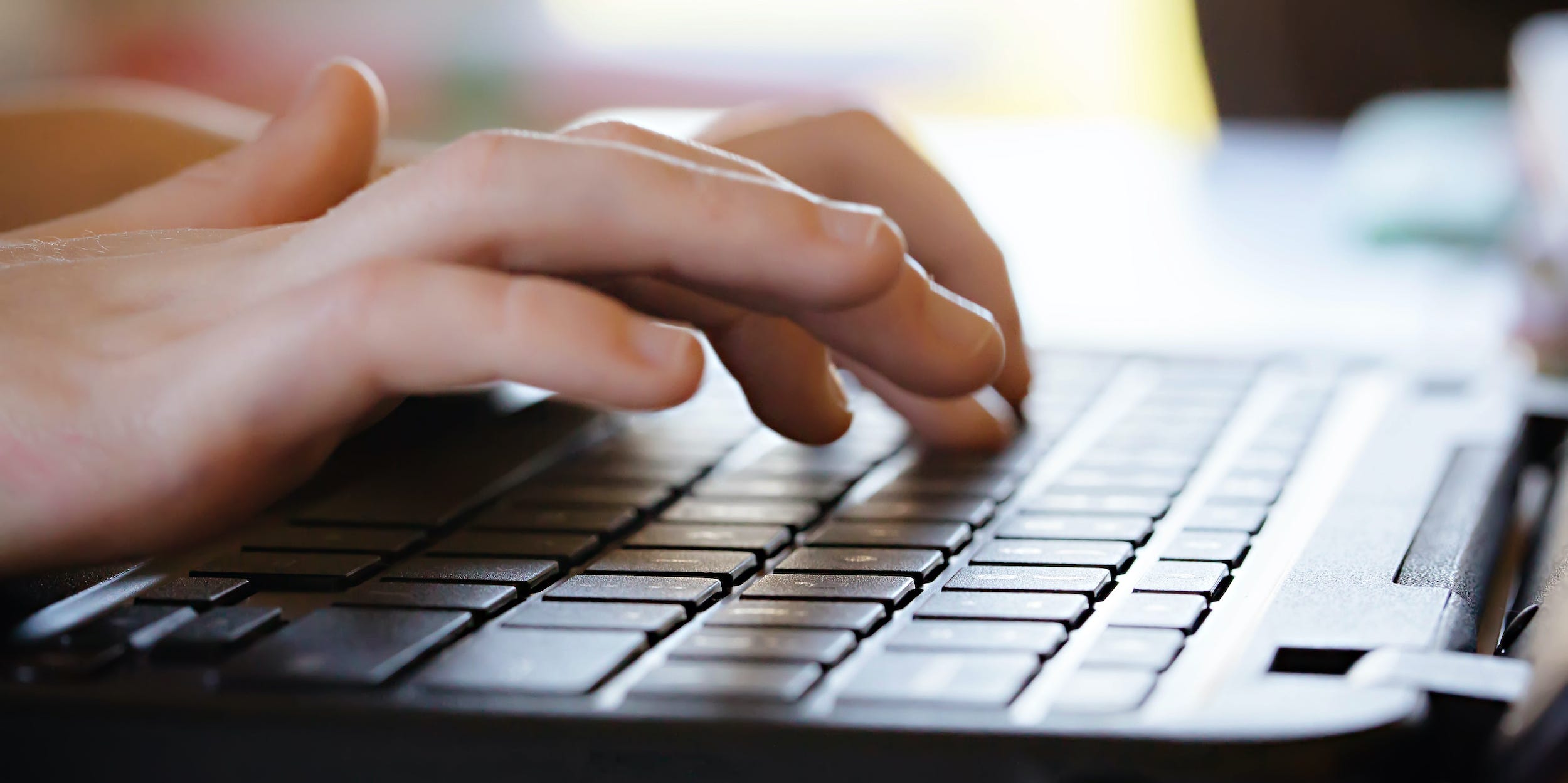 hands typing on laptop keyboard PC