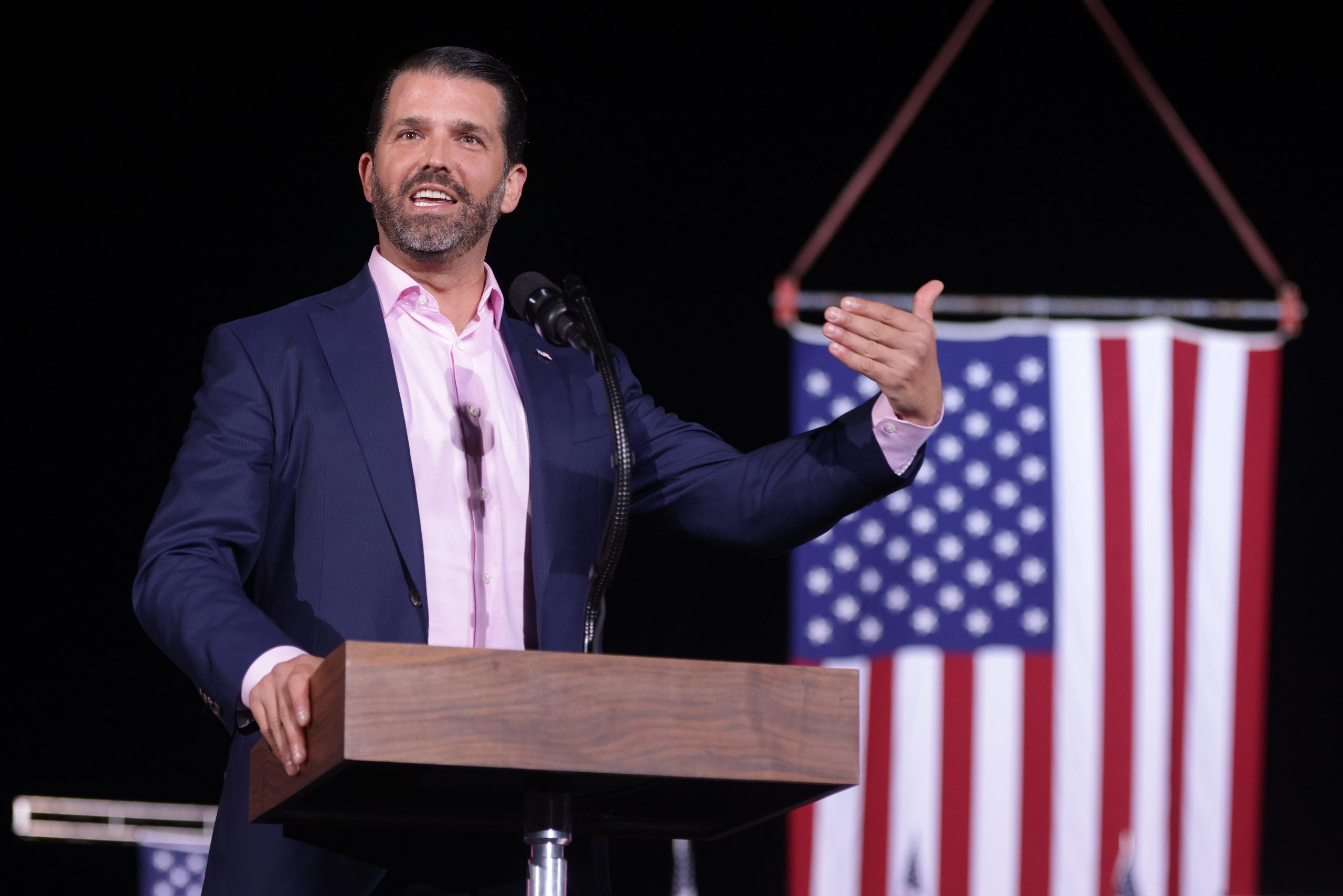 Donald Trump Jr stands at pulpit in front of American flag