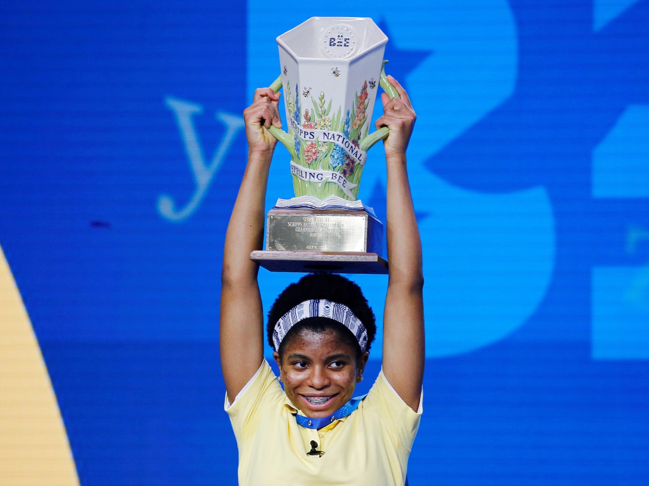 Zaila Avant-garde hoists her Spelling Bee trophy above her head.