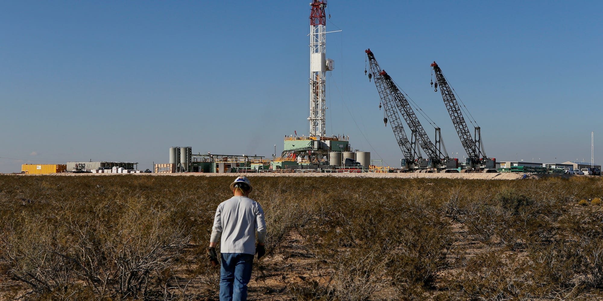 oil worker walks toward a drill rig in Loving County, Texas