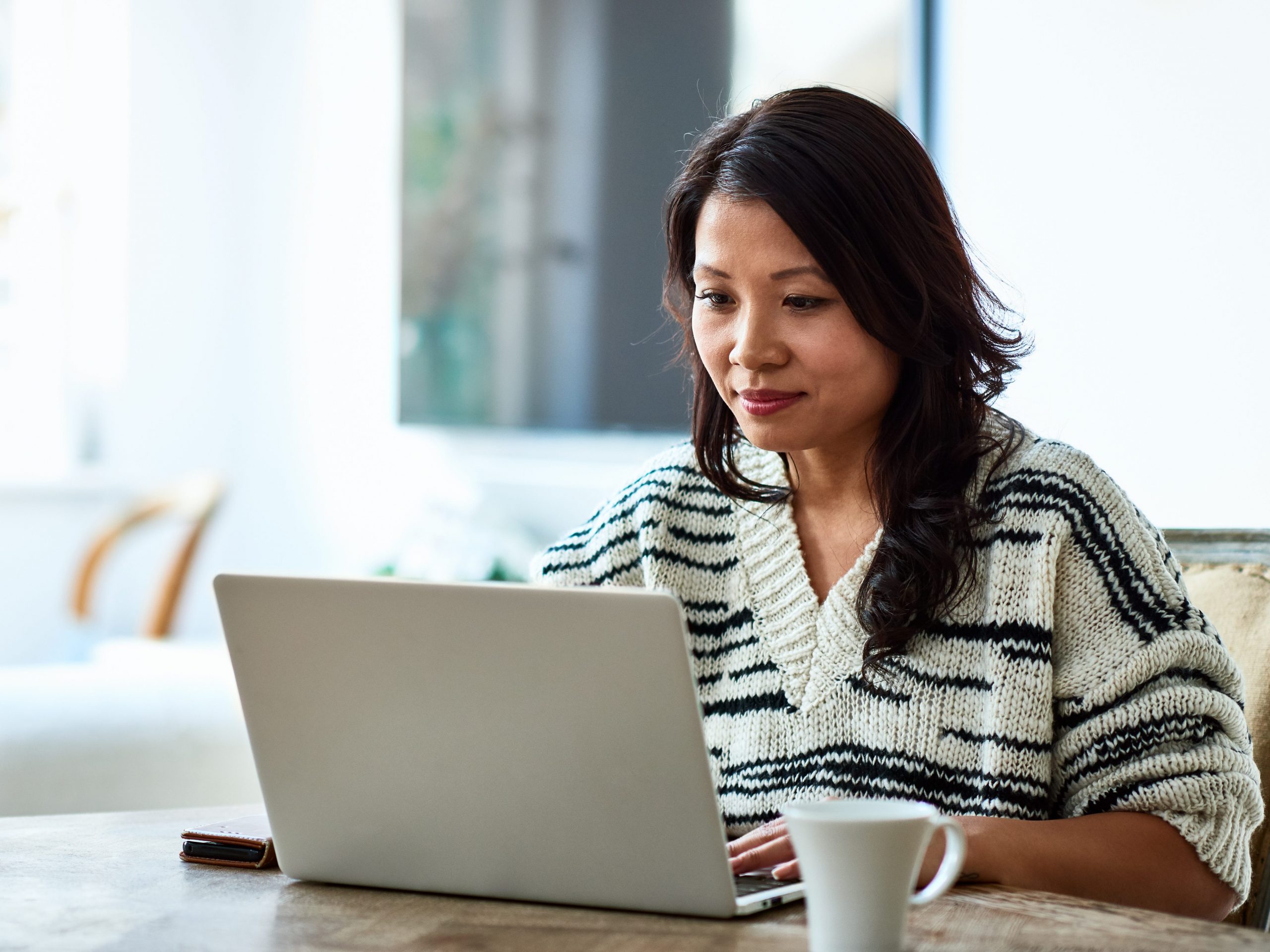 Woman sits in front of laptop.