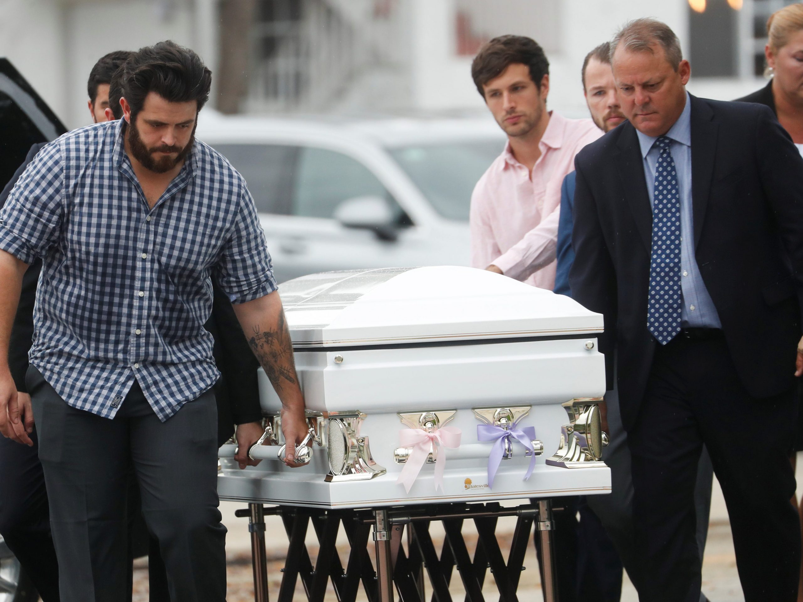 An image of pallbearers taking the casket shared by Emma and Lucia Guara, 11 and 4, thought to be the youngest victims of the Miami condo collapse