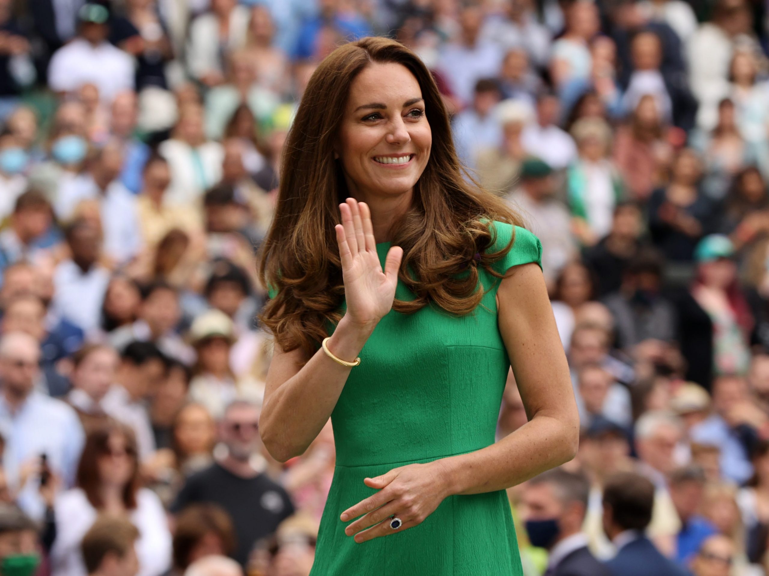 Kate Middleton wears a green dress and waves to the crowd at Wimbledon.