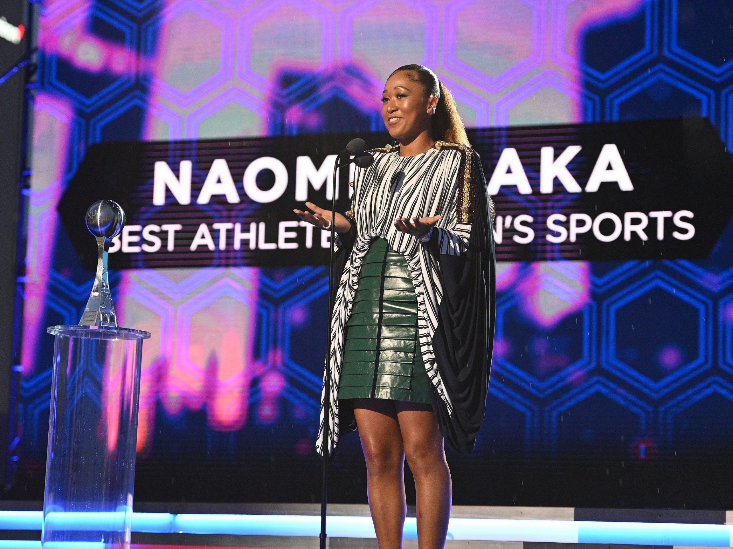 Naomi Osaka stands onstage at the ESPY Awards to accept the Best Athlete in Women's Sports award.