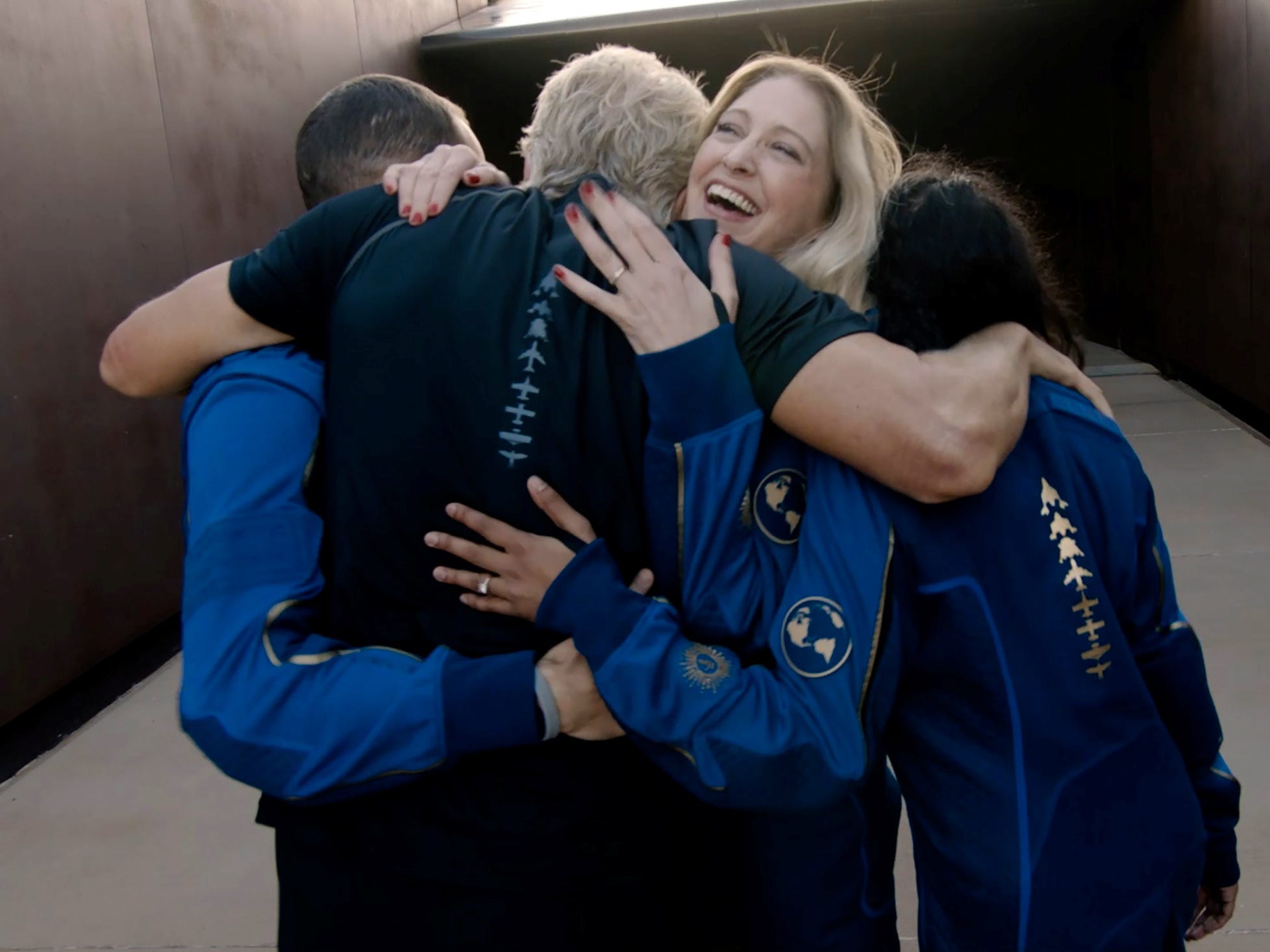 beth moses other virgin galactic crew in astronaut jumpsuits embrace richard branson