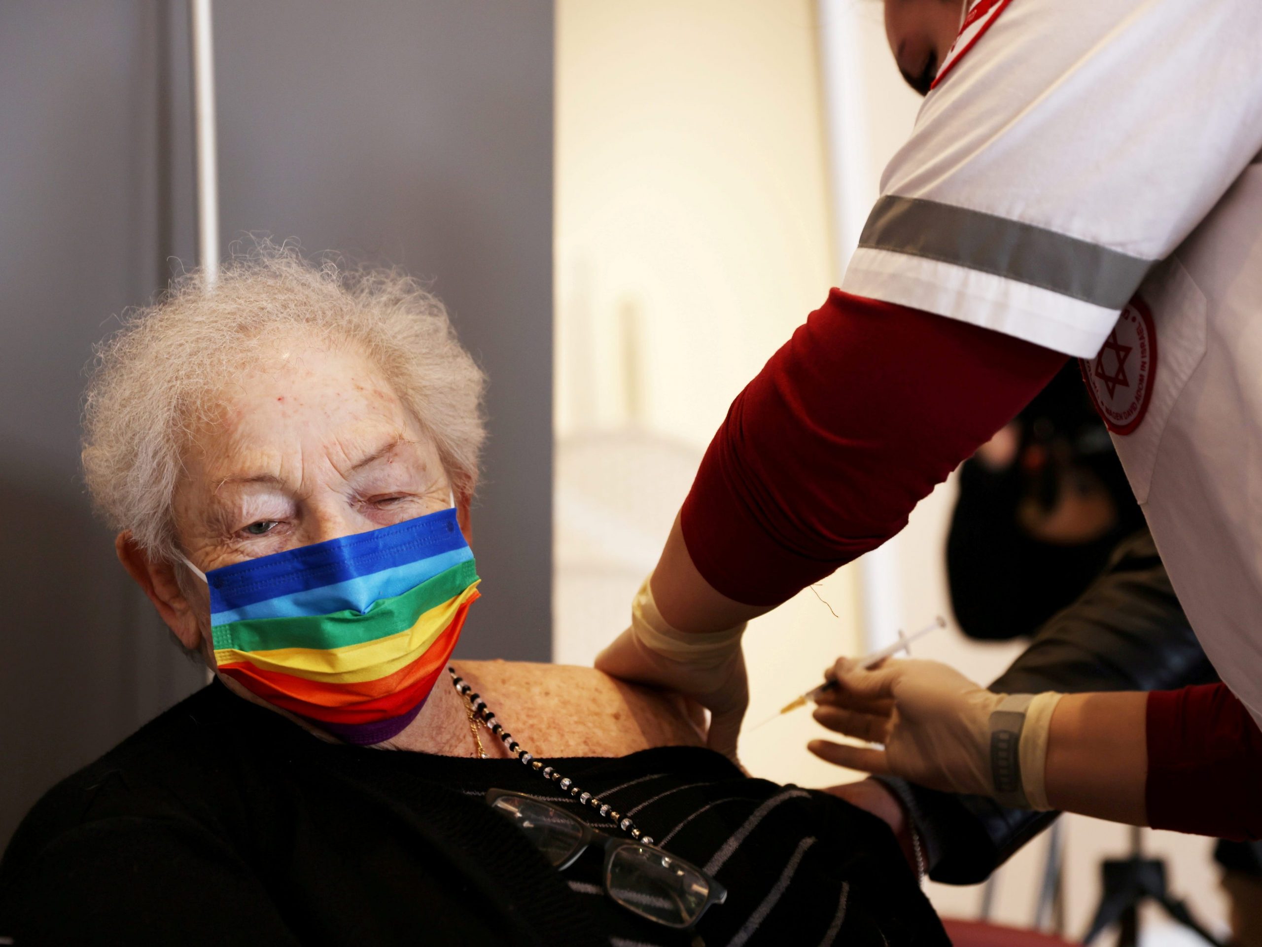 An elderly woman receives a booster shot of her vaccination against the coronavirus disease (COVID-19) at an assisted living facility, in Netanya, Israel, January 19, 2021.