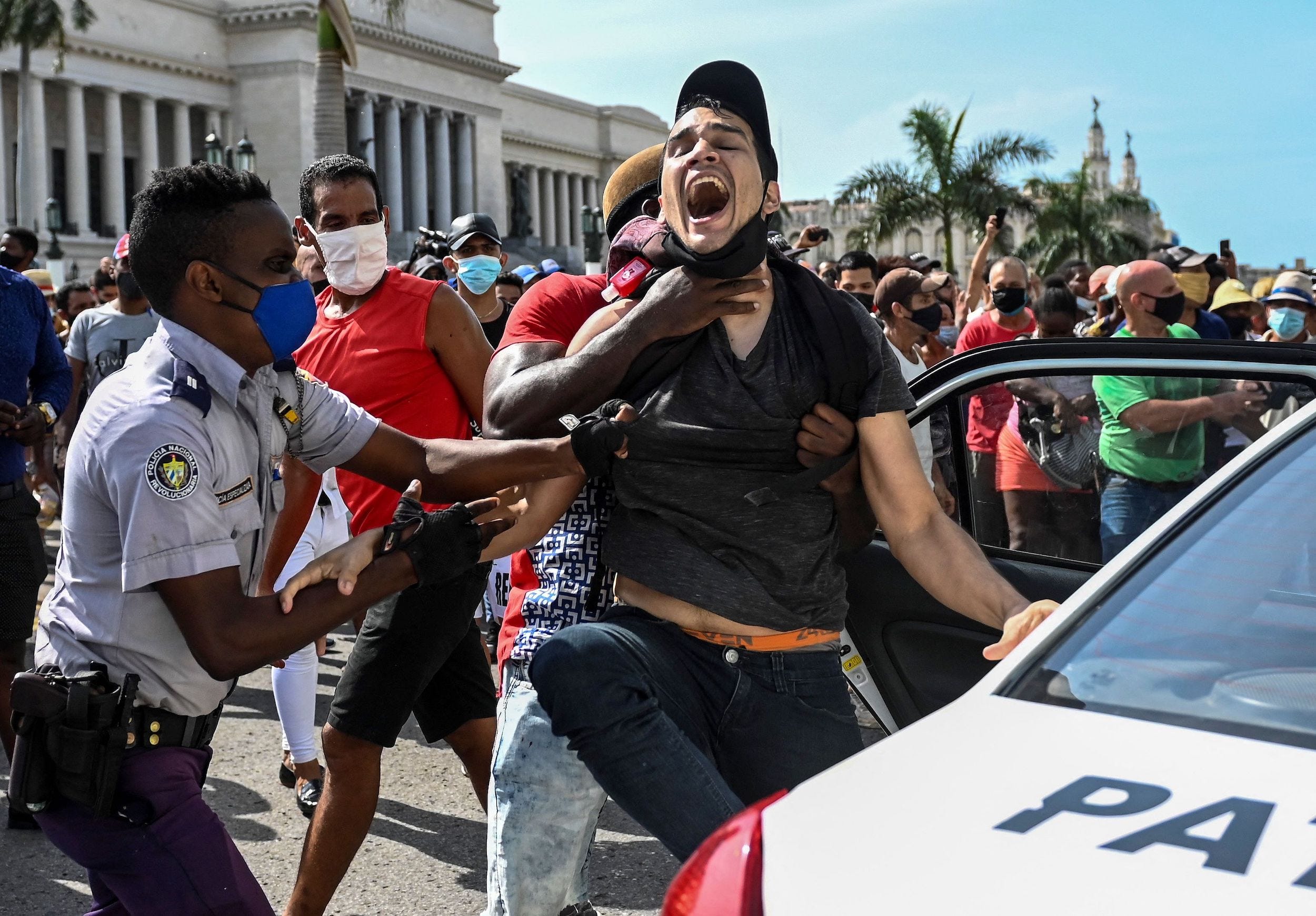 A man is arrested during a protest against the Cuban government