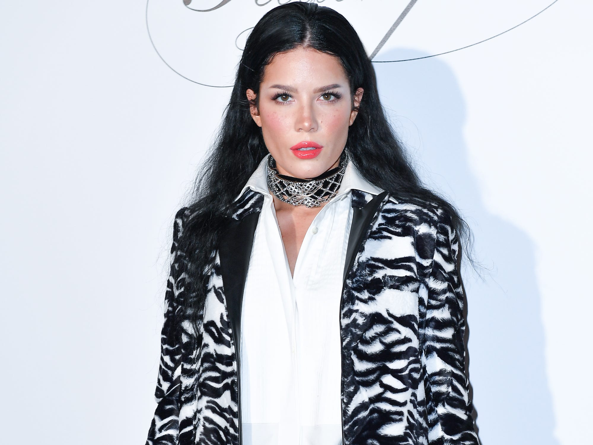 halsey with long black hair posing against white background