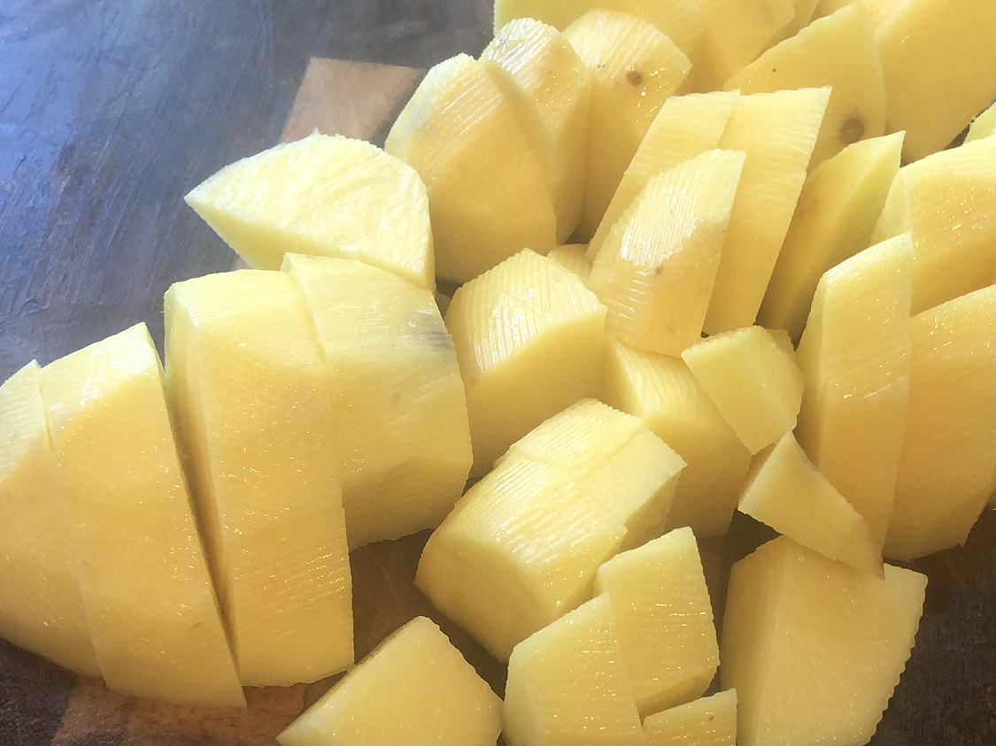 diced potatoes on a wooden cutting board