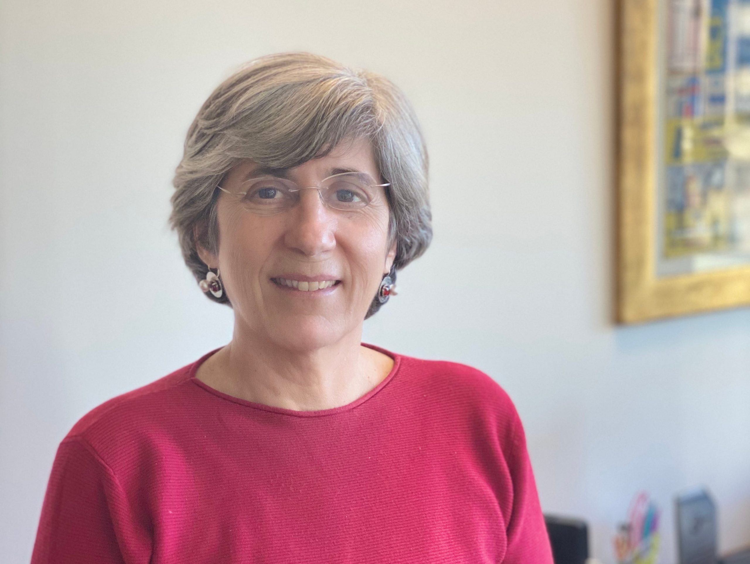 Manuela Veloso, JPMorgan's head of AI research, poses in a room wearing a red sweater.