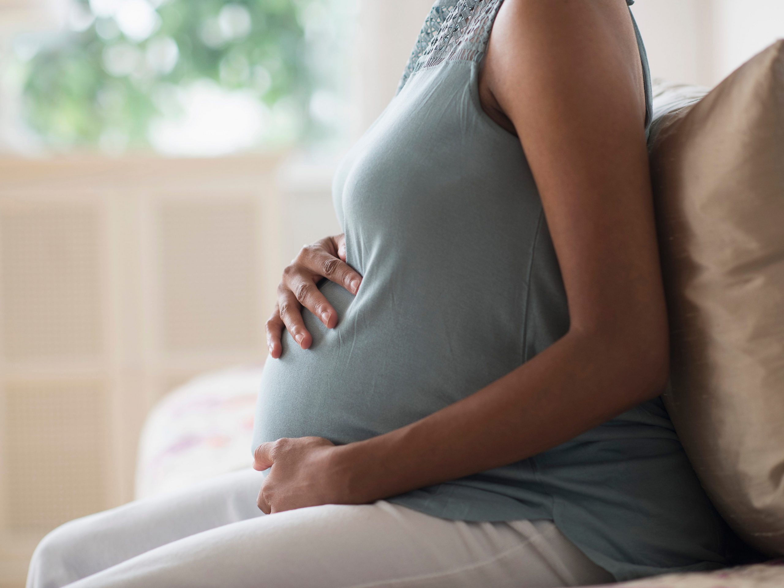 A pregnant mother holding her stomach.