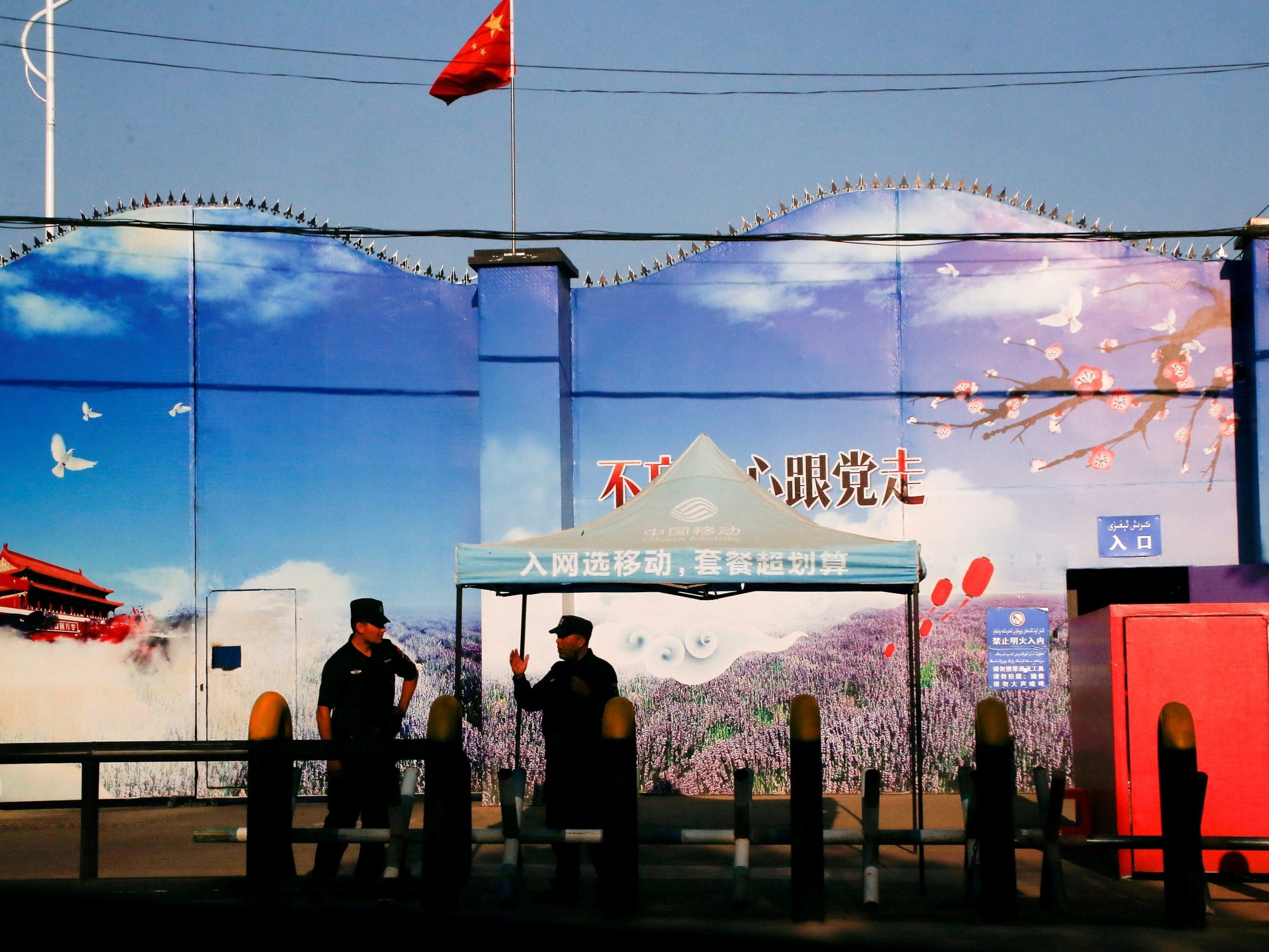 Security guards stand at the gates of what is officially known as a vocational skills education centre in Huocheng County