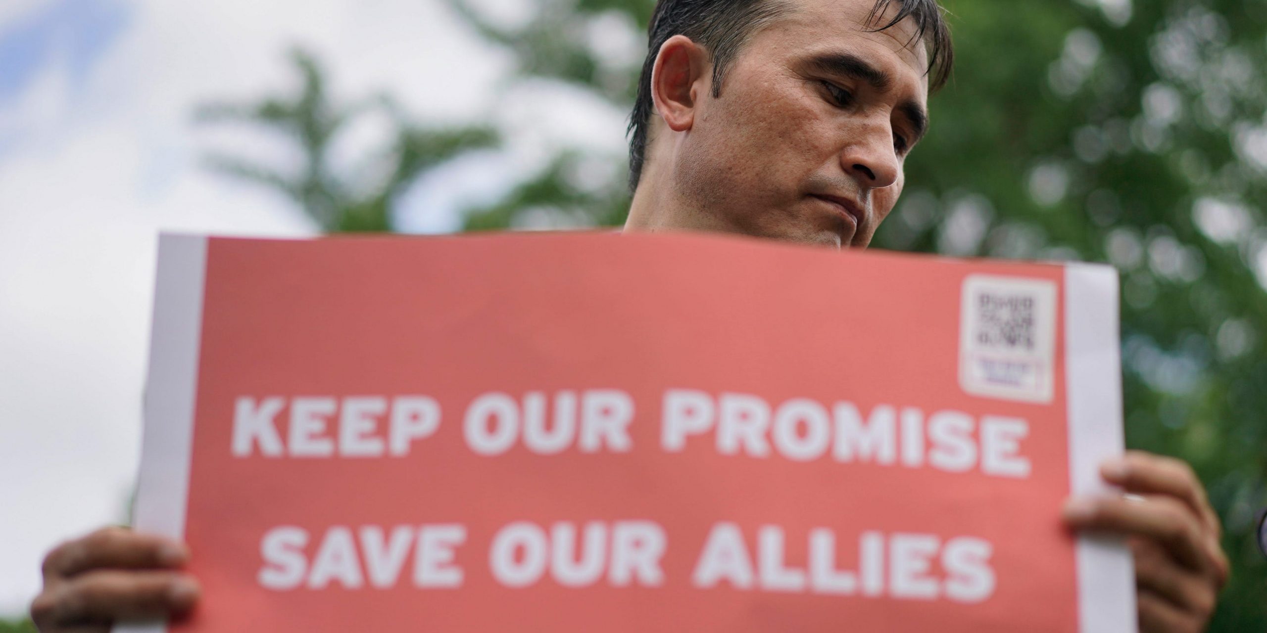 Abdul Wahid Forozan, a former translator for the American military in Afghanistan, holds a sign during a rally near the White House in July 2021.