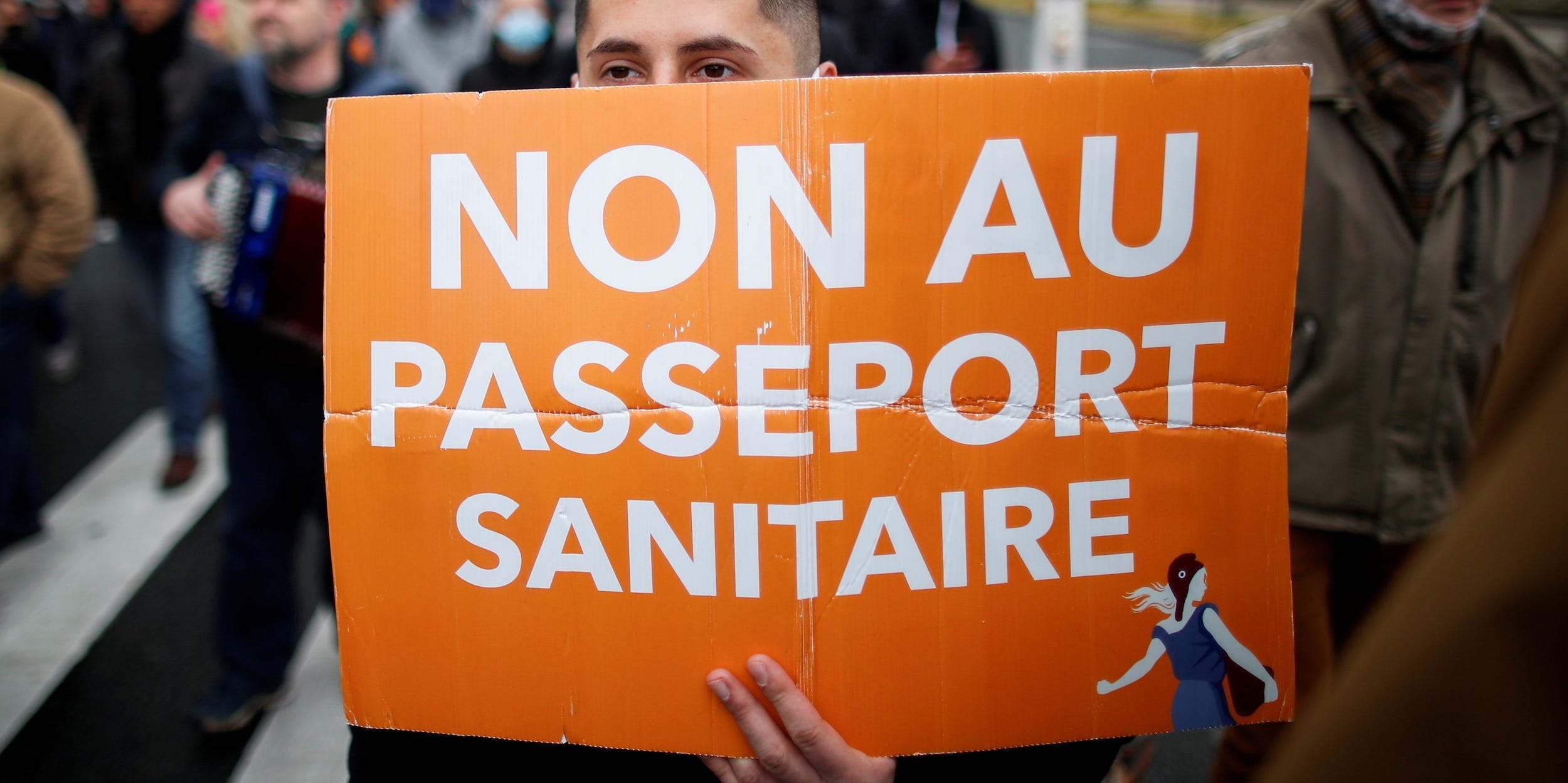 A supporter of French nationalist party "Les Patriotes" (The Patriots) holds a placard during a protest against government's economic and social policies during the coronavirus disease (COVID-19) outbreak in Paris, France April 10,2021. The placard reads "No to the health passport".