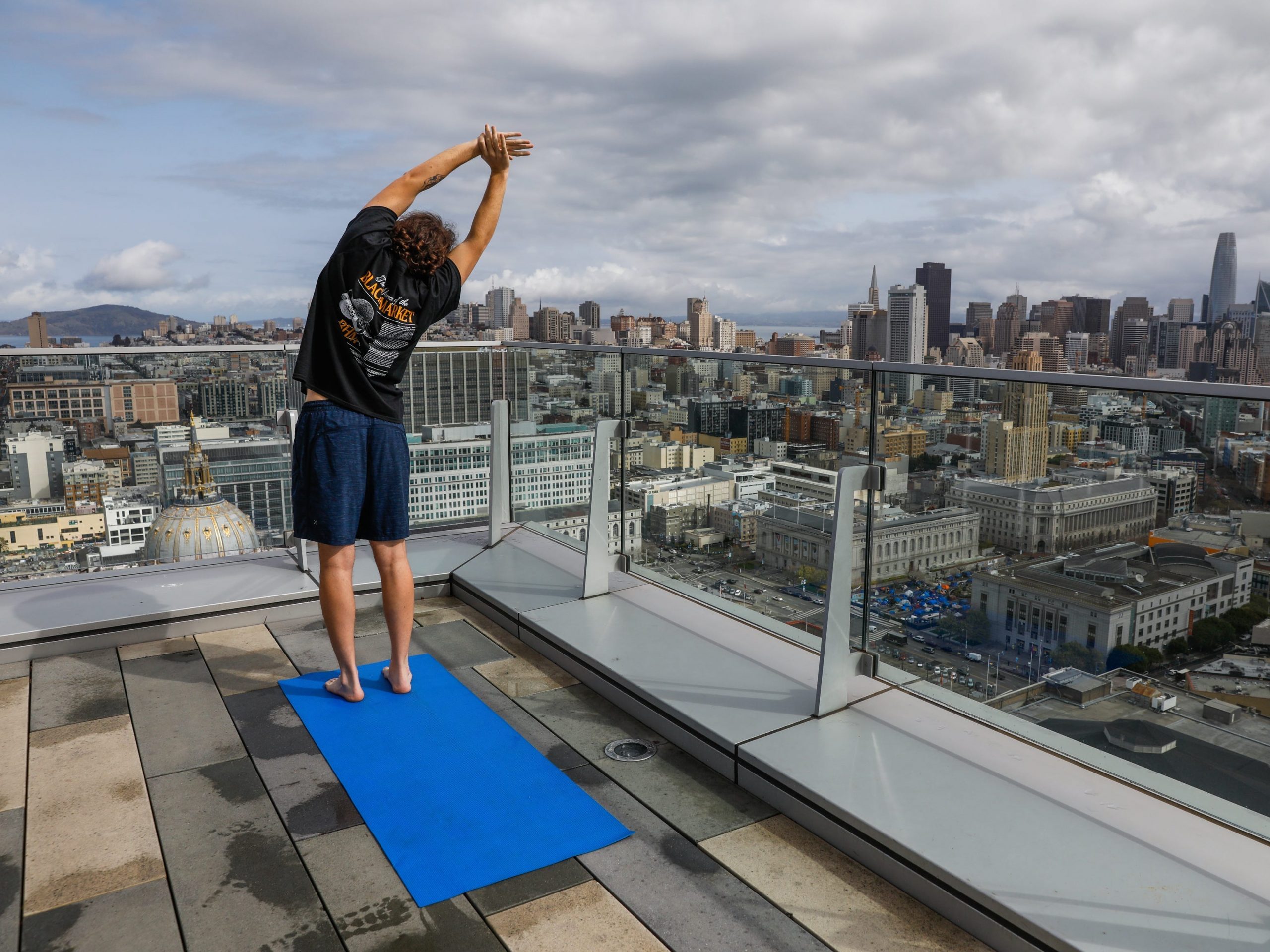 Resident Emmet Dettweiler does yoga on the roof of the 100 Van Ness apartment building on Friday, March 19, 2021 in San Francisco, California.