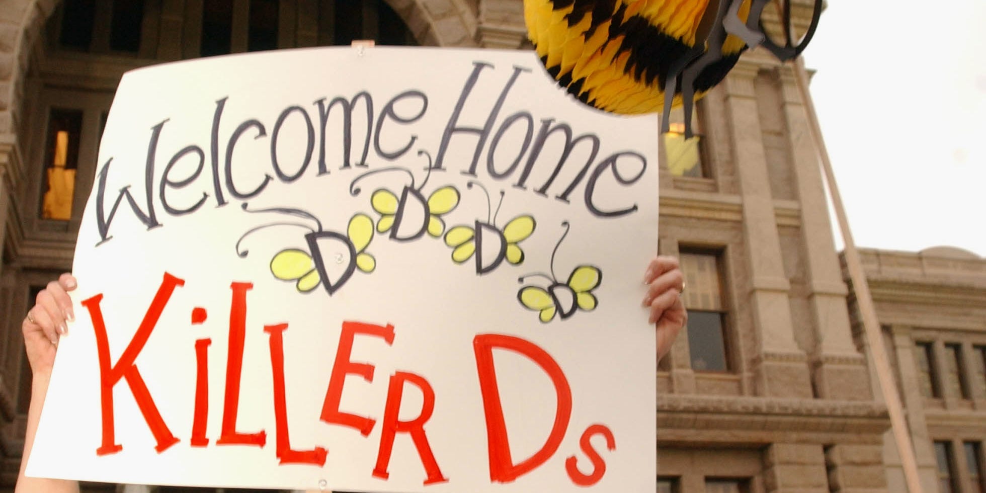 A woman holds up a sign to welcome back Texas lawmakers who fled the state to block a redistricting bill