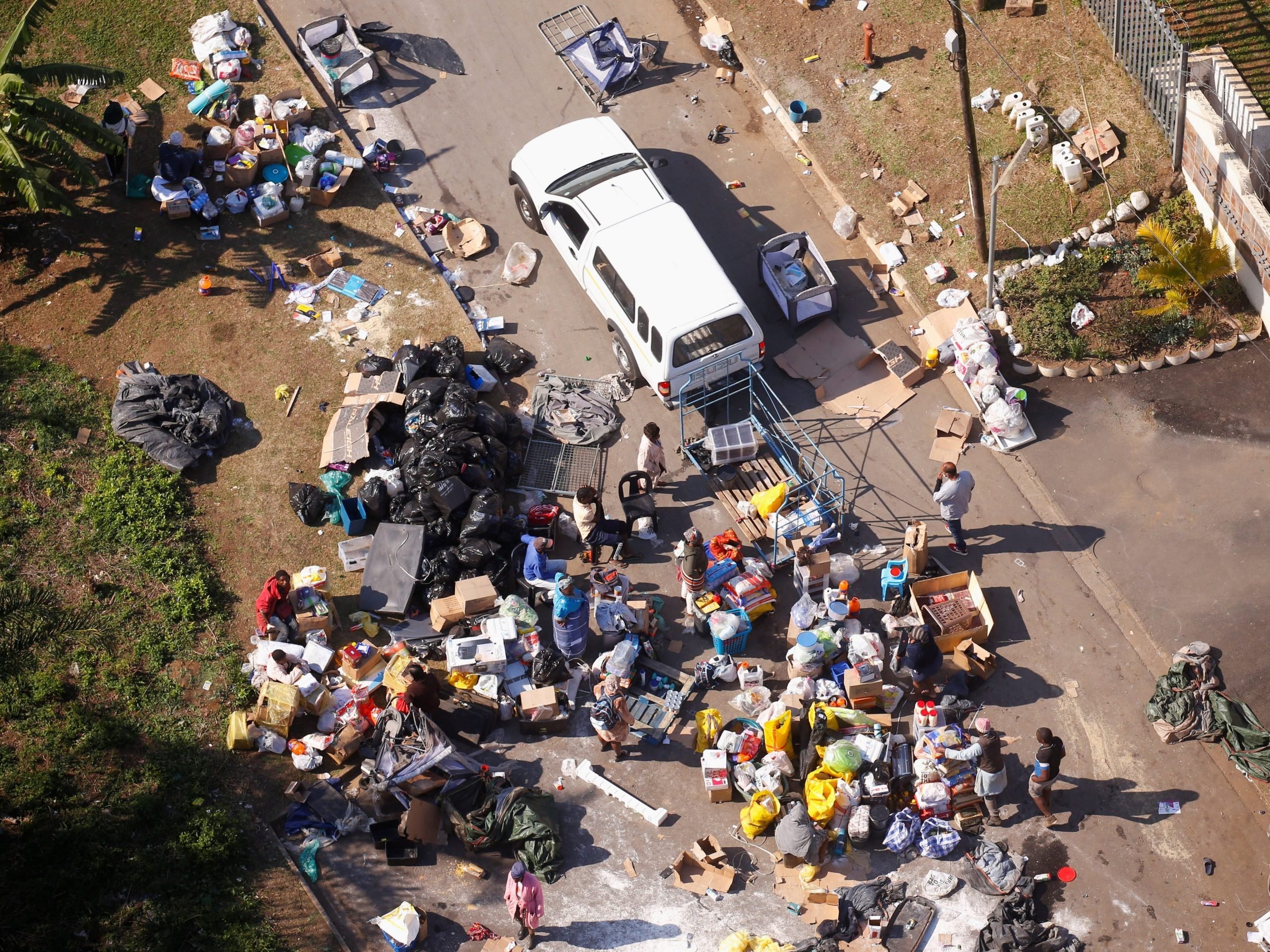 People loot an area near a burning warehouse in Durban, South Africa