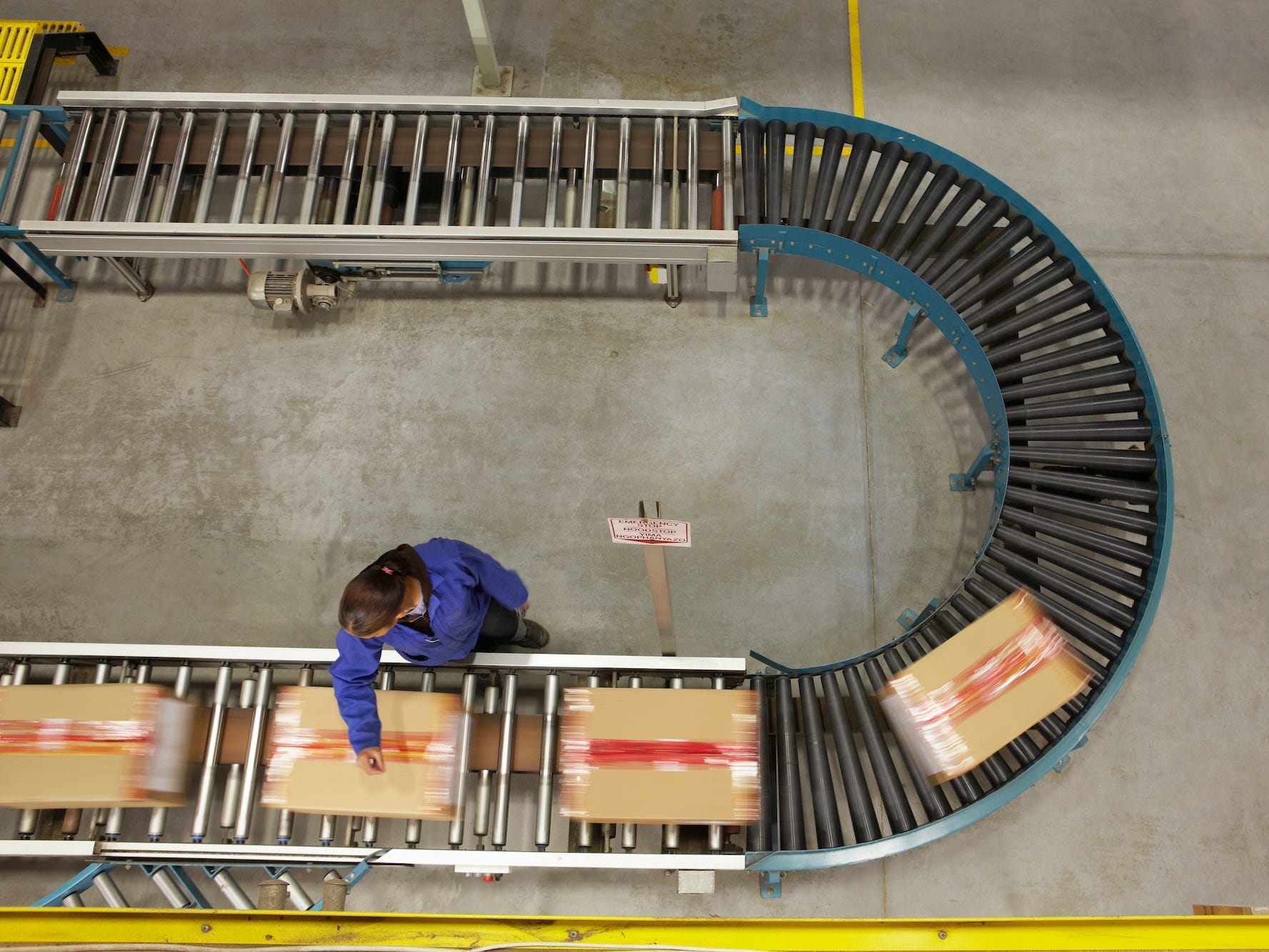 worker scanning boxes on a conveyor belt in a warehouse