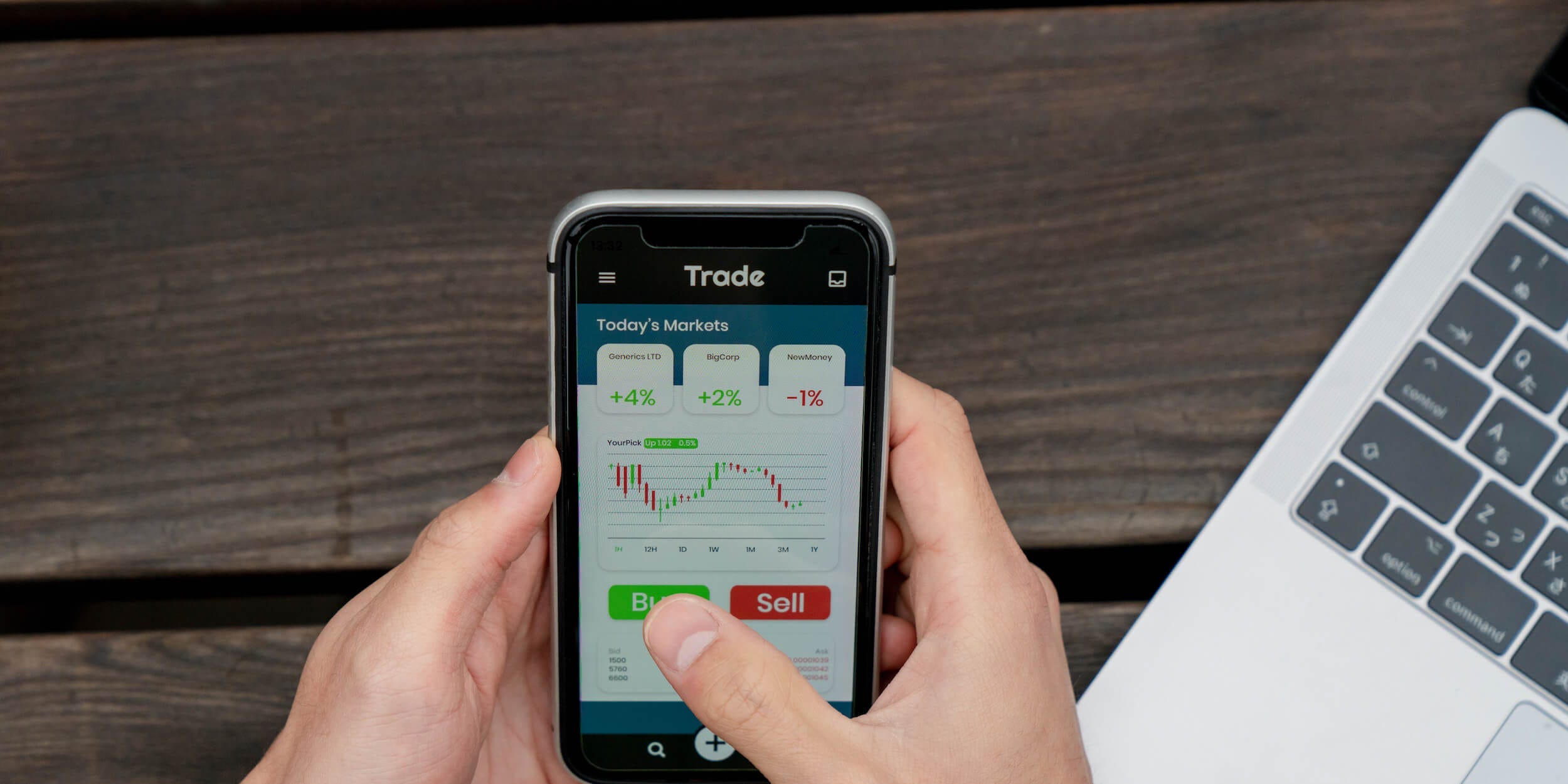 Above angle view of a young man using a trading app.