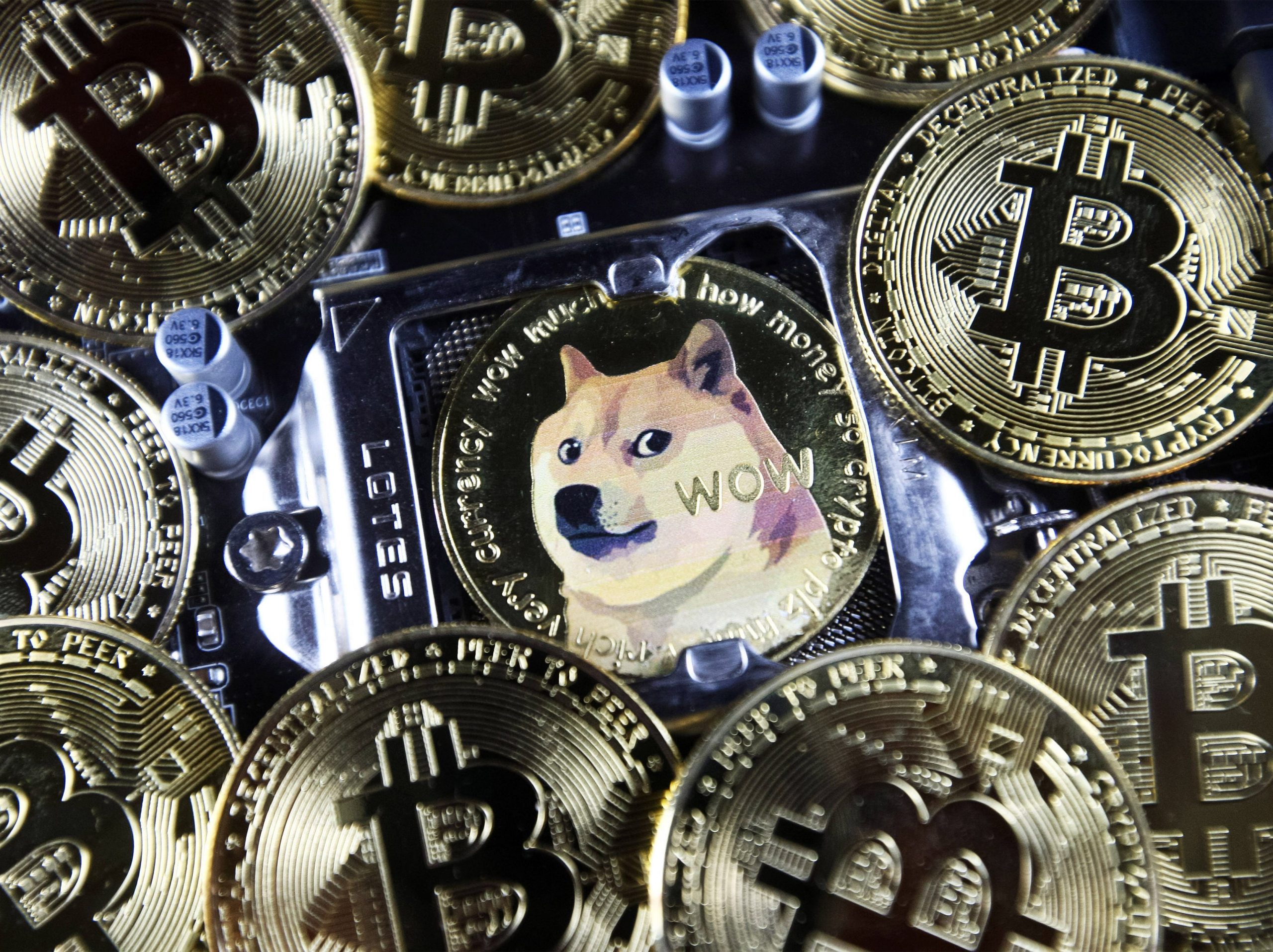 Dogecoin and Bitcoin cryptocurrency coins are pictured in Kyiv on 08 July, 2021.