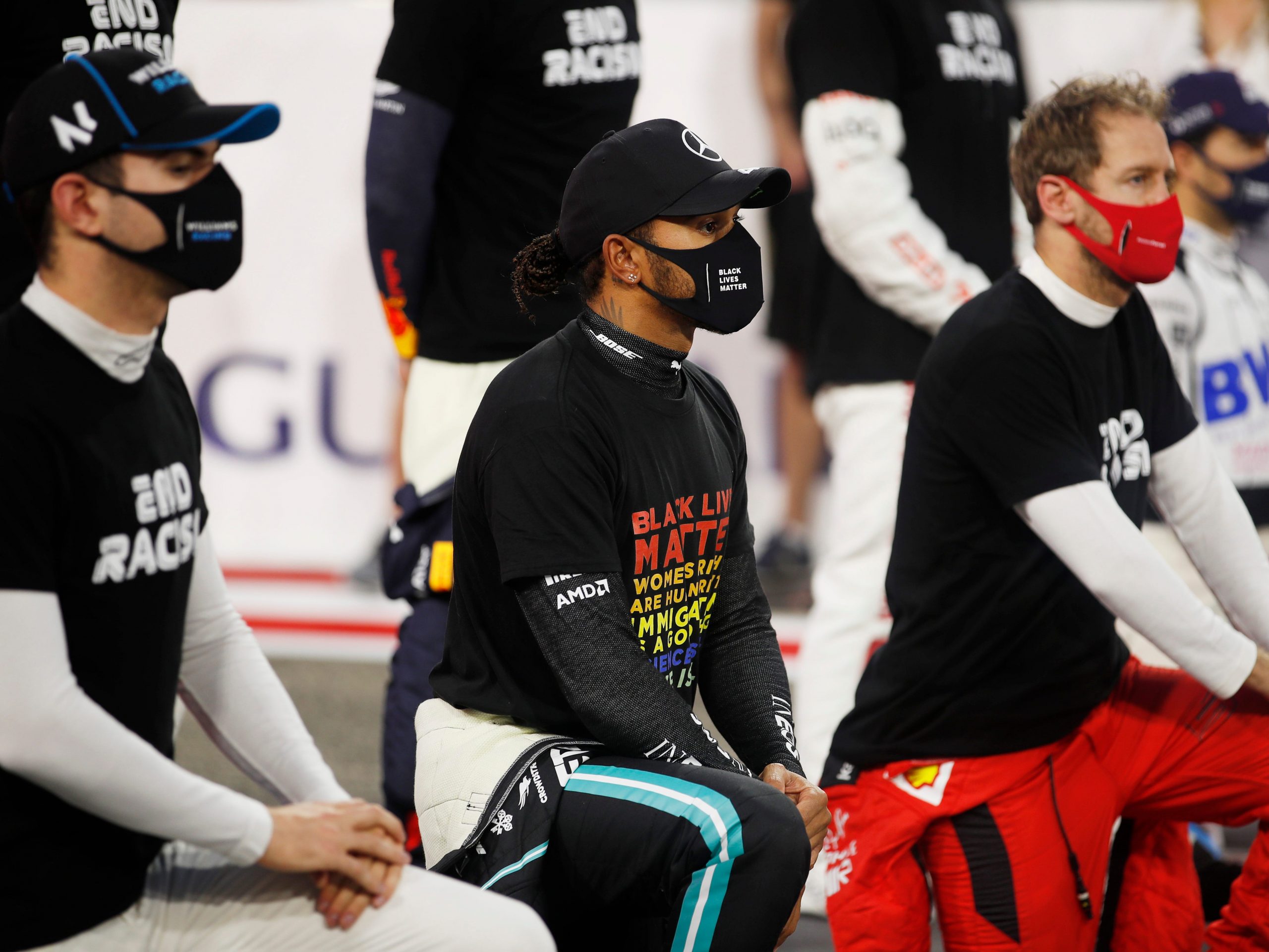 Lewis Hamilton of Great Britain and Mercedes GP (C), Nicholas Latifi of Canada and Williams (L) and Sebastian Vettel of Germany and Ferrari (R) take a knee on the grid in support of the Black Lives Matter movement prior to the F1 Grand Prix of Bahrain at Bahrain International Circuit