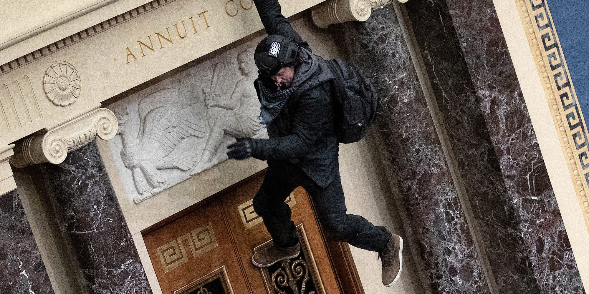A man identified by the FBI as Josiah Colt dangling from the Senate balcony during the Capitol riot on January 6, 2021.