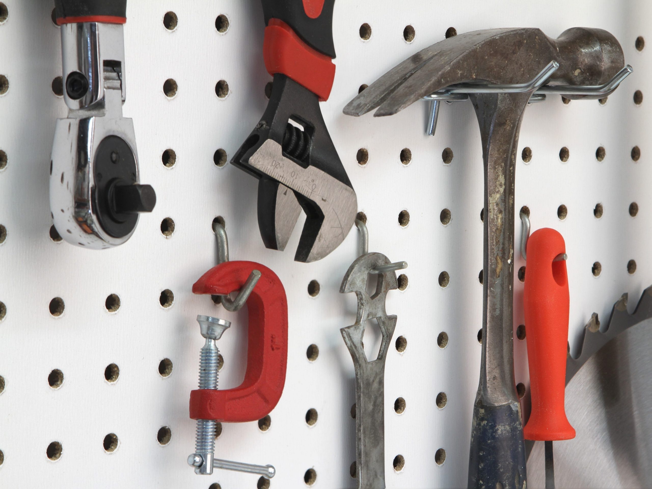 Various tools hanging on a pegboard.