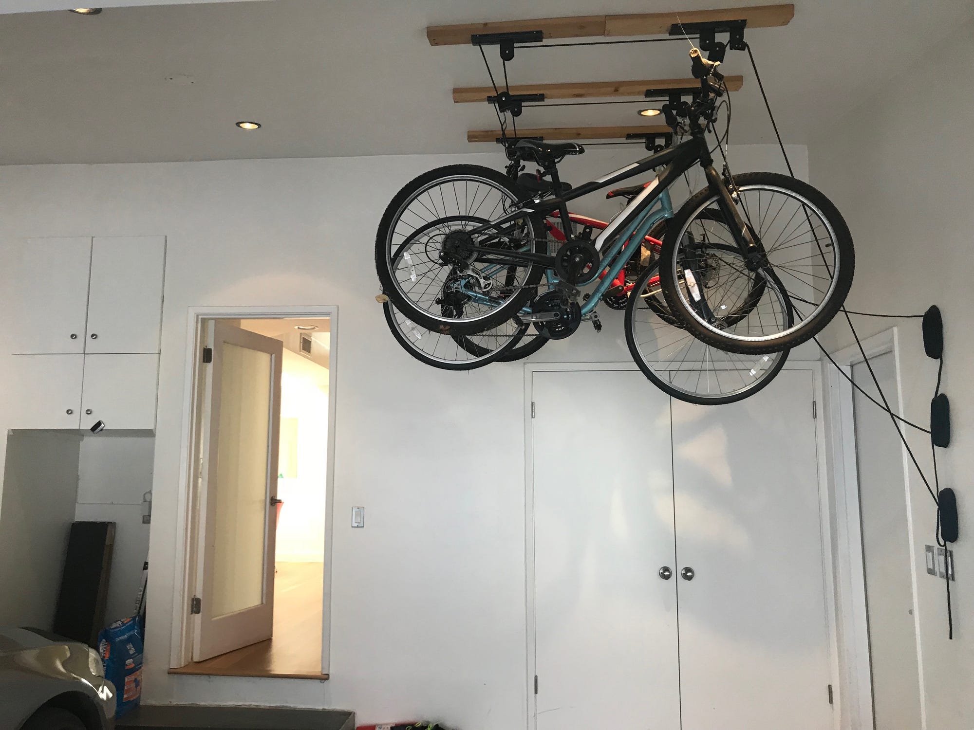 Bicycles hanging from the ceiling in a garage.