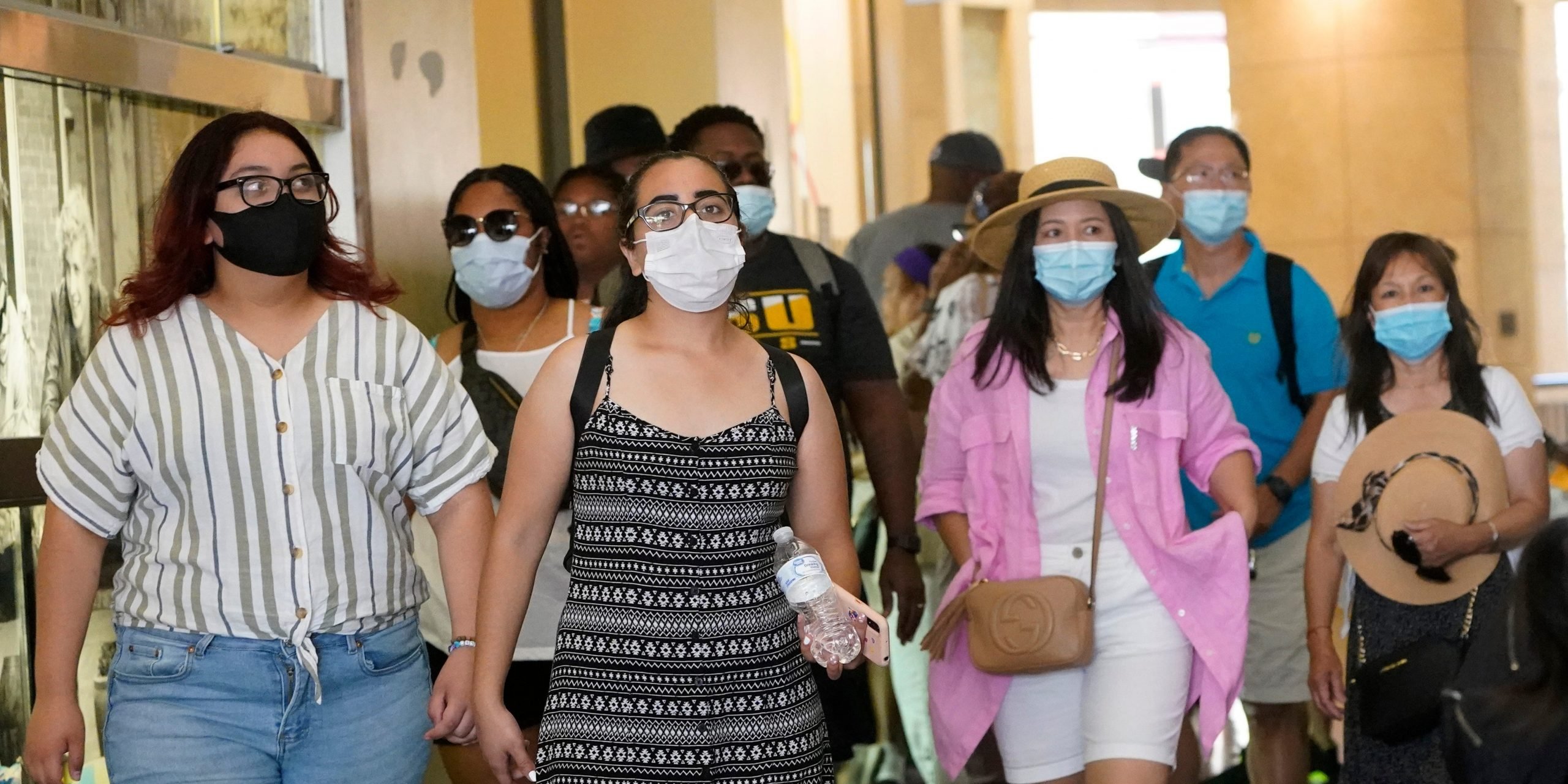 Shoppers in a mall wear masks.