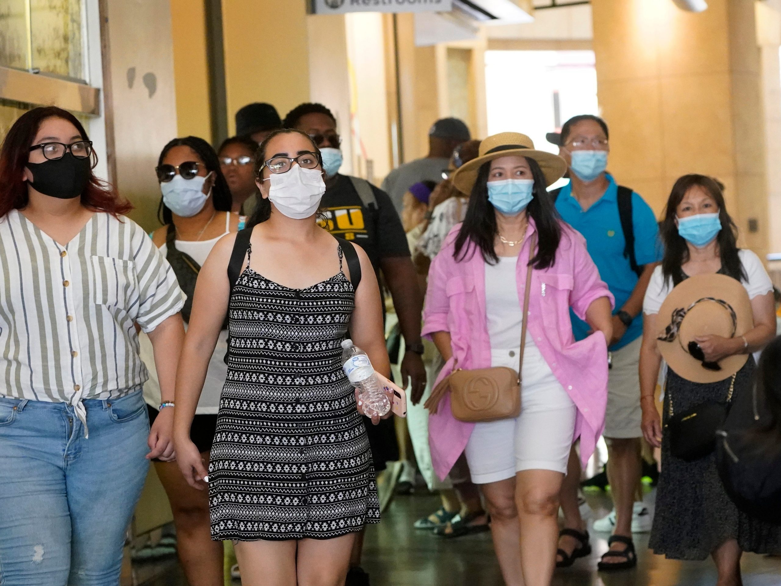 Shoppers in a mall wear masks.