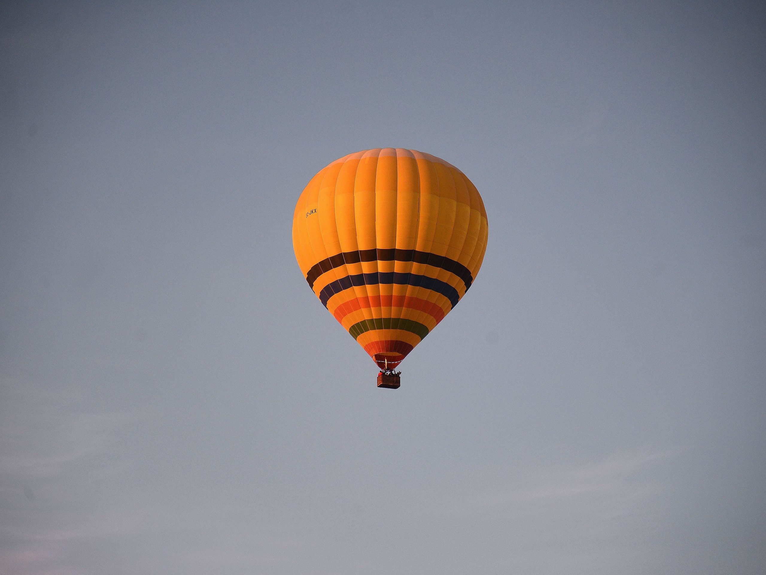 A yellow hot air balloon in the sky.