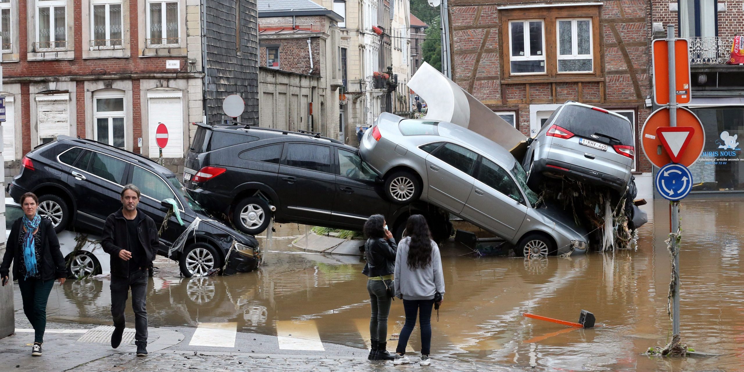 People standing by cars piled up at a roundabout in the Belgian city of Verviers