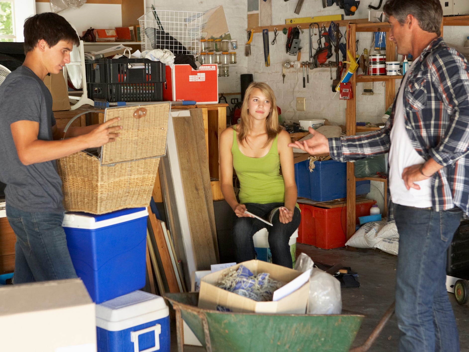 Three people organizing a garage together.