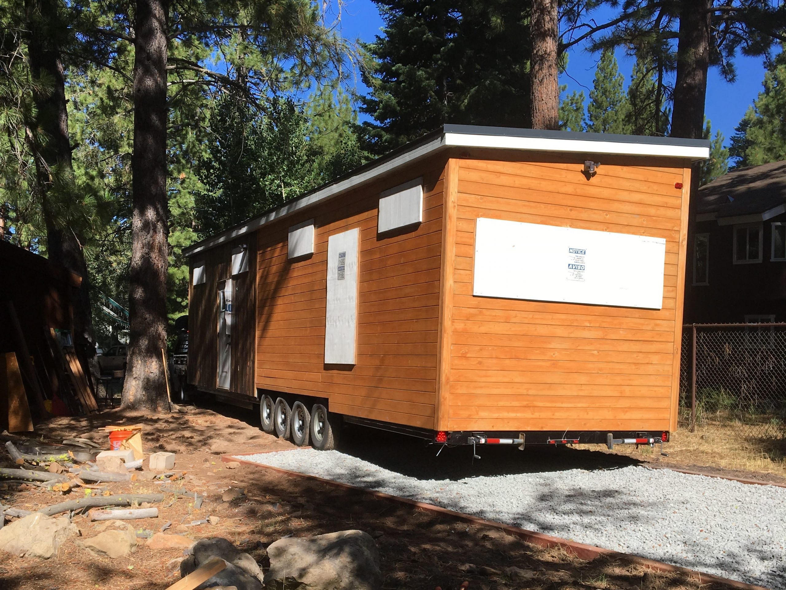partially built tiny home on a railer in a forested area