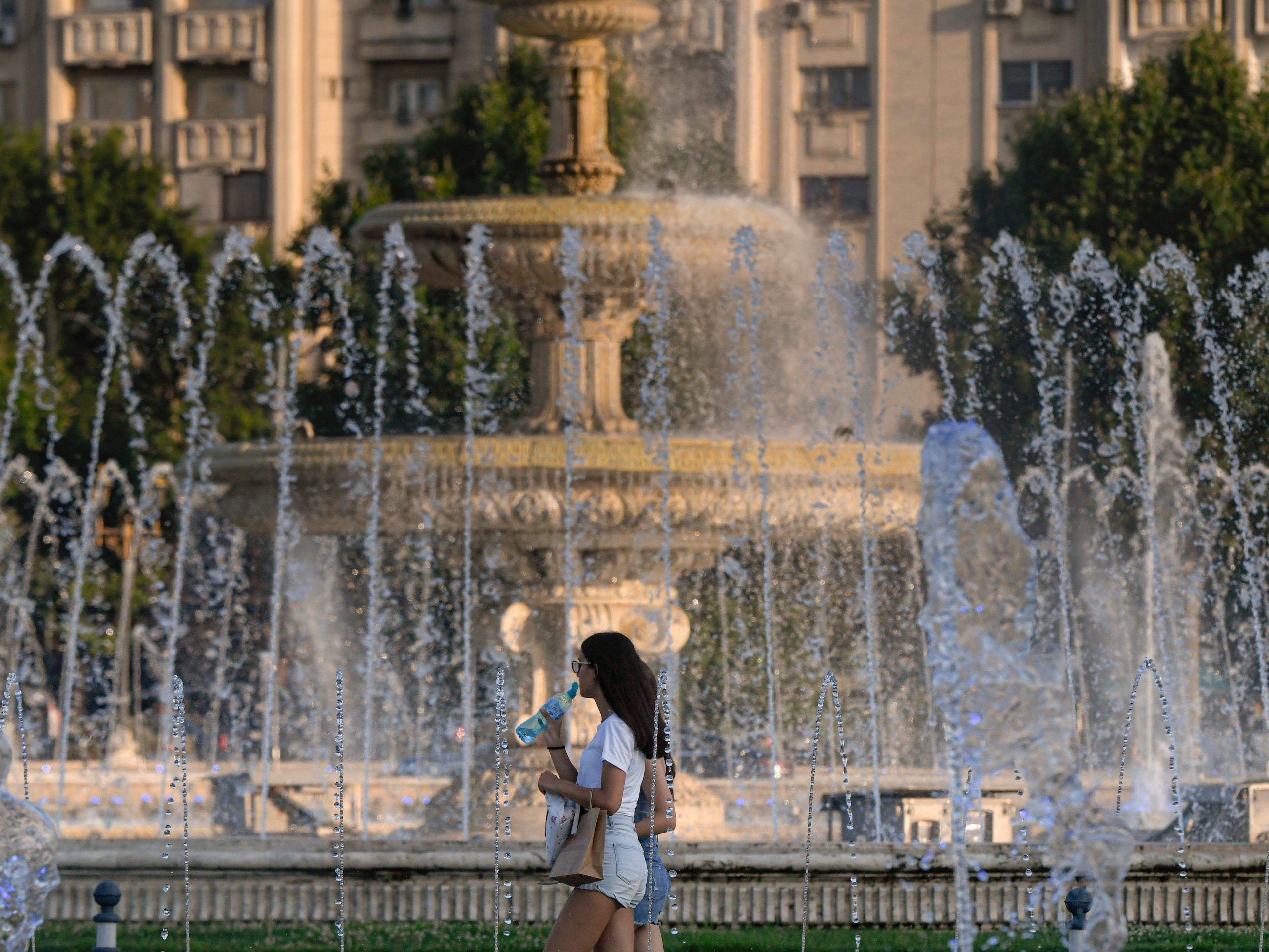Woman walking in front of fountain