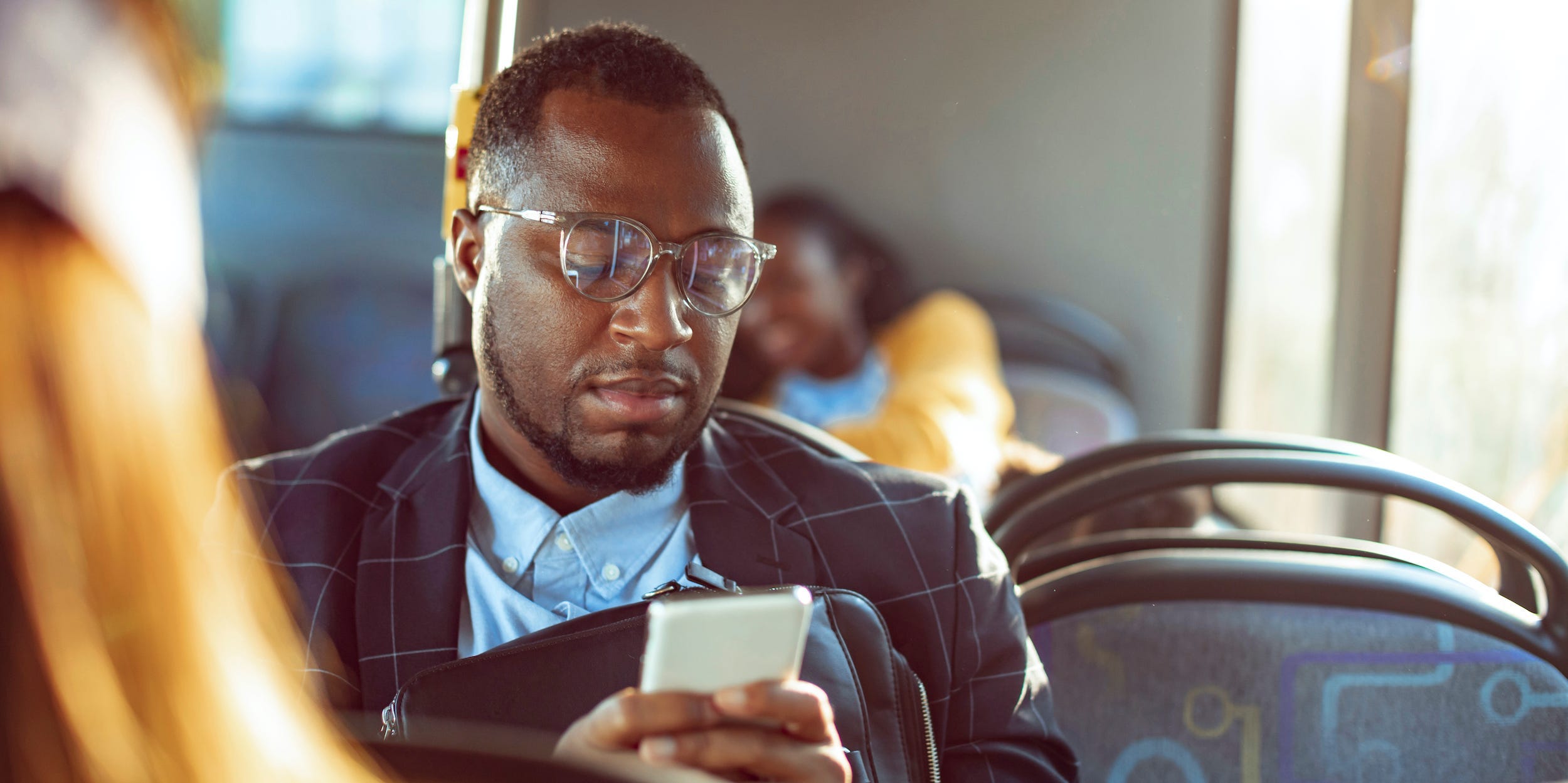 Commuter on bus looking at phone