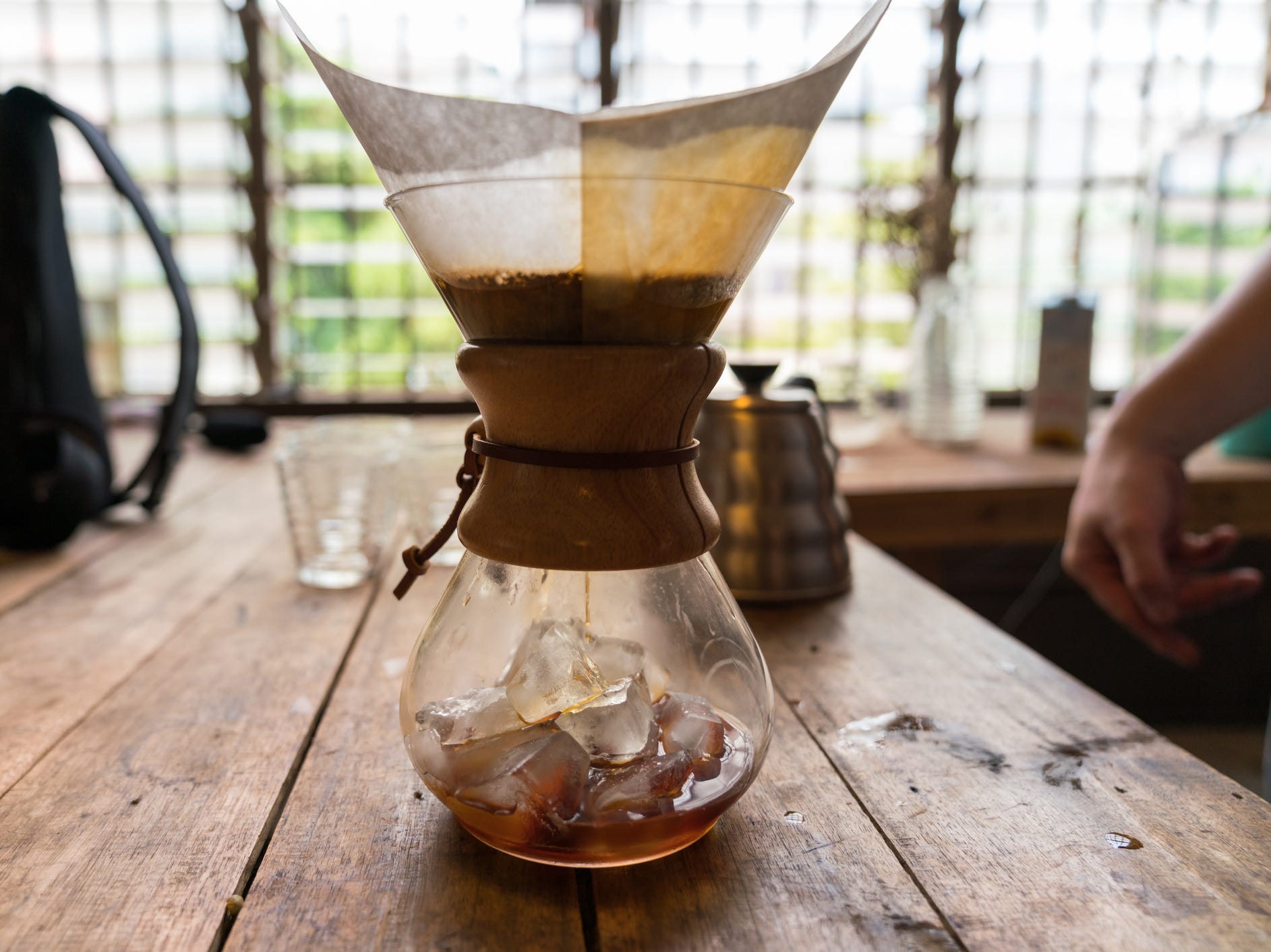 A chemex pour over coffee maker with ice in the base