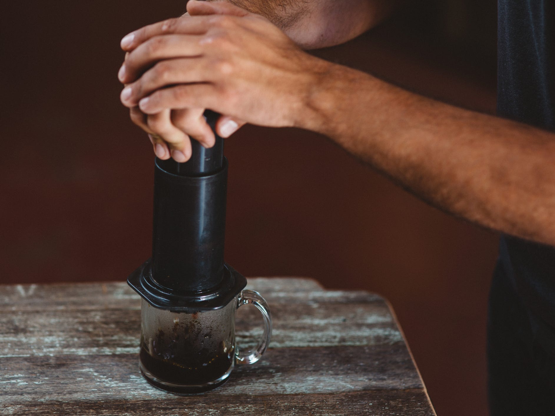 A pair of hands making coffee using an Aeropress