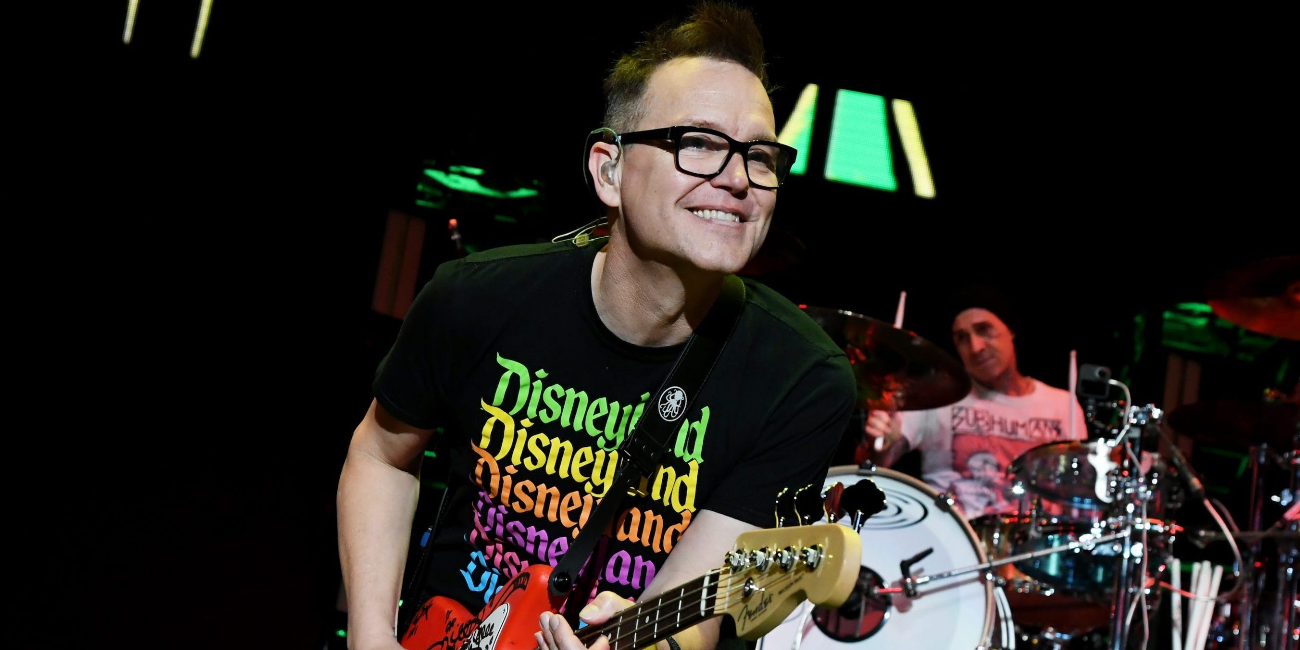 Mark Hoppus of Blink-182 playing guitar onstage