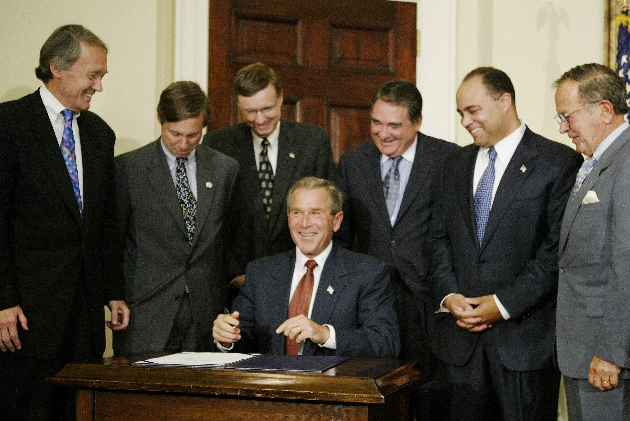 President George W. Bush laughing before signing a bill at the White House in 2003